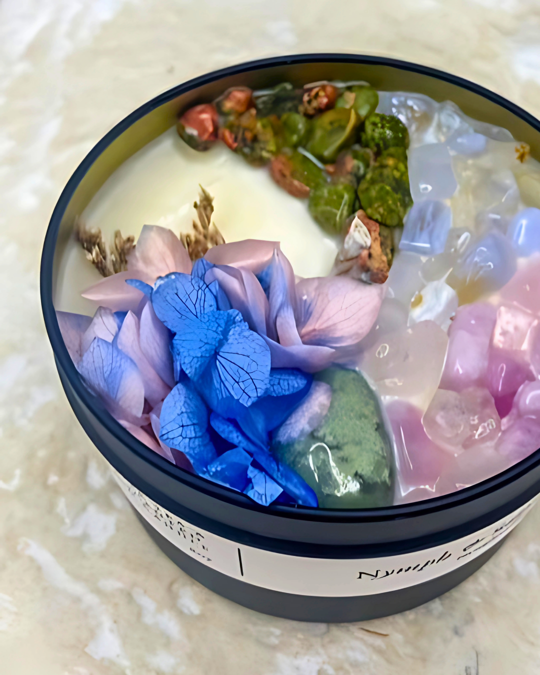 Decorative container with colorful butterfly and flower elements on a textured surface