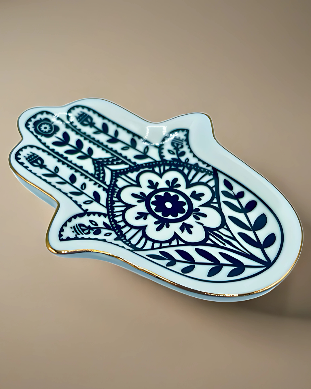 Decorative plate shaped like a hand with blue floral design on a beige background