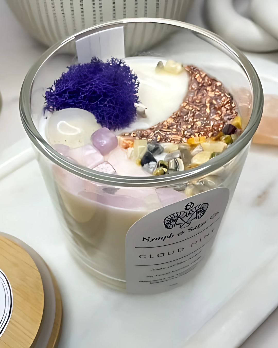 Decorative candle with colorful elements and a visible brand label on a white surface.