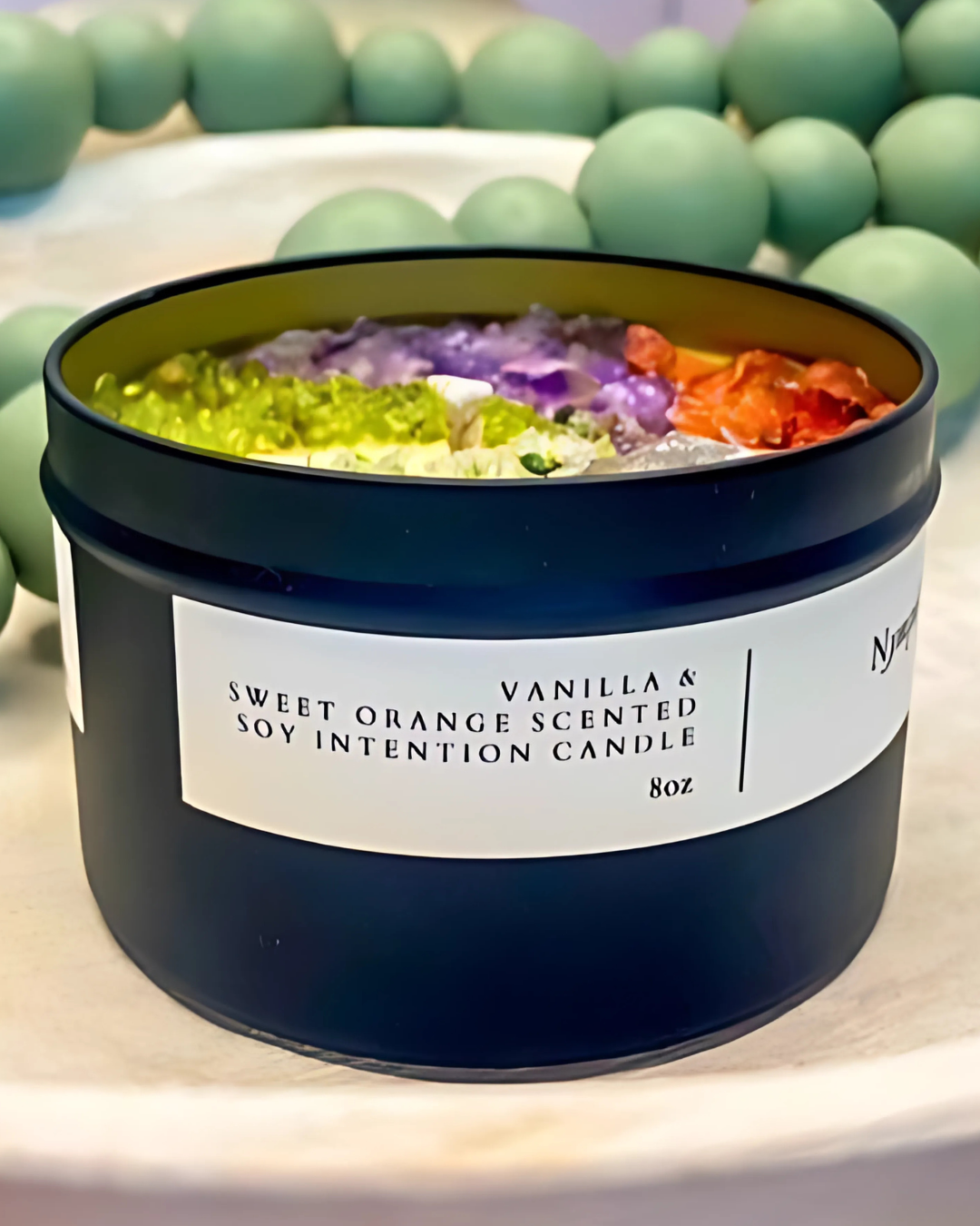 Scented candle with colorful beads and a label on a light background
