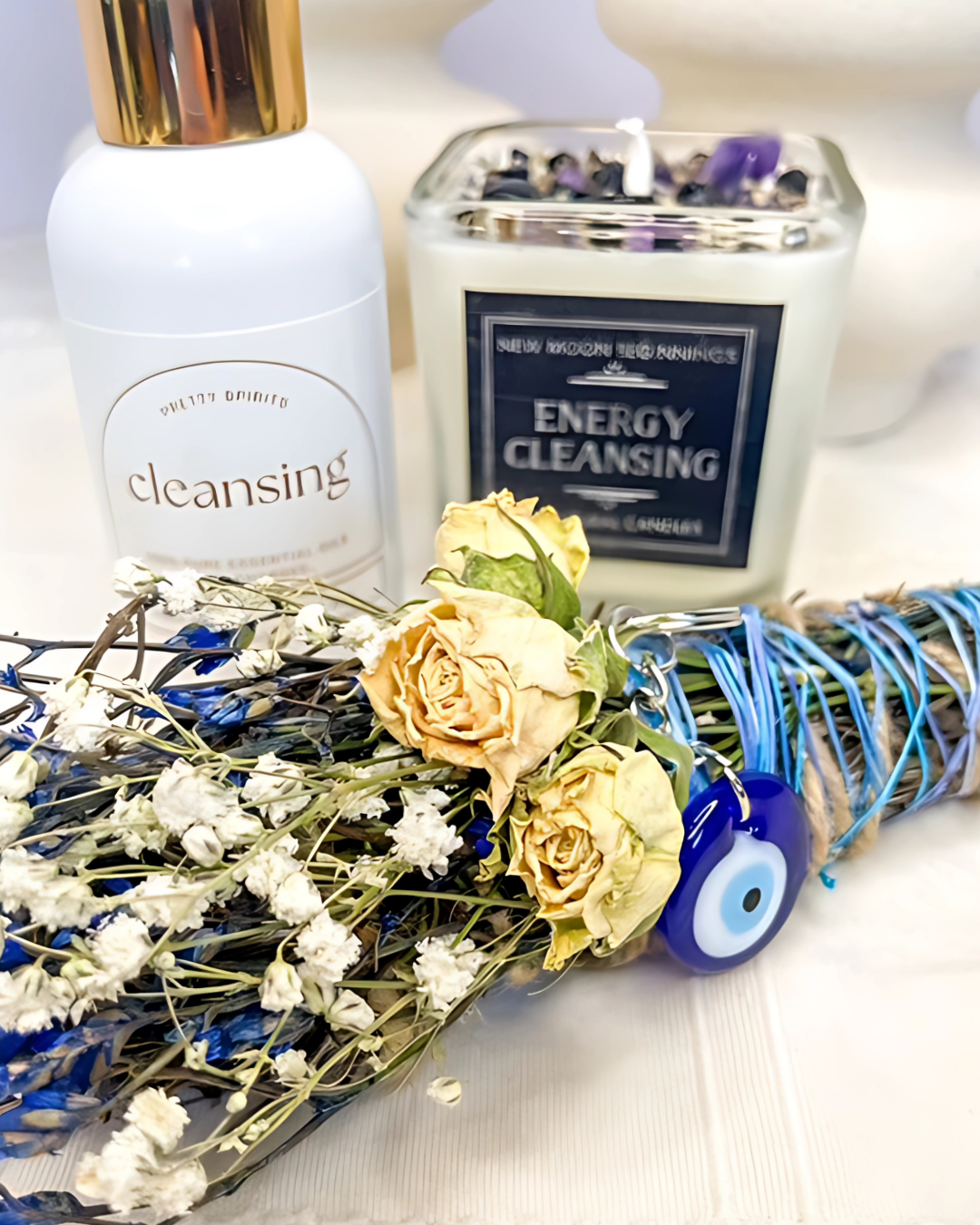 Candle labeled 'Energy Cleansing' with flowers and a bottle labeled 'cleansing' on a white background
