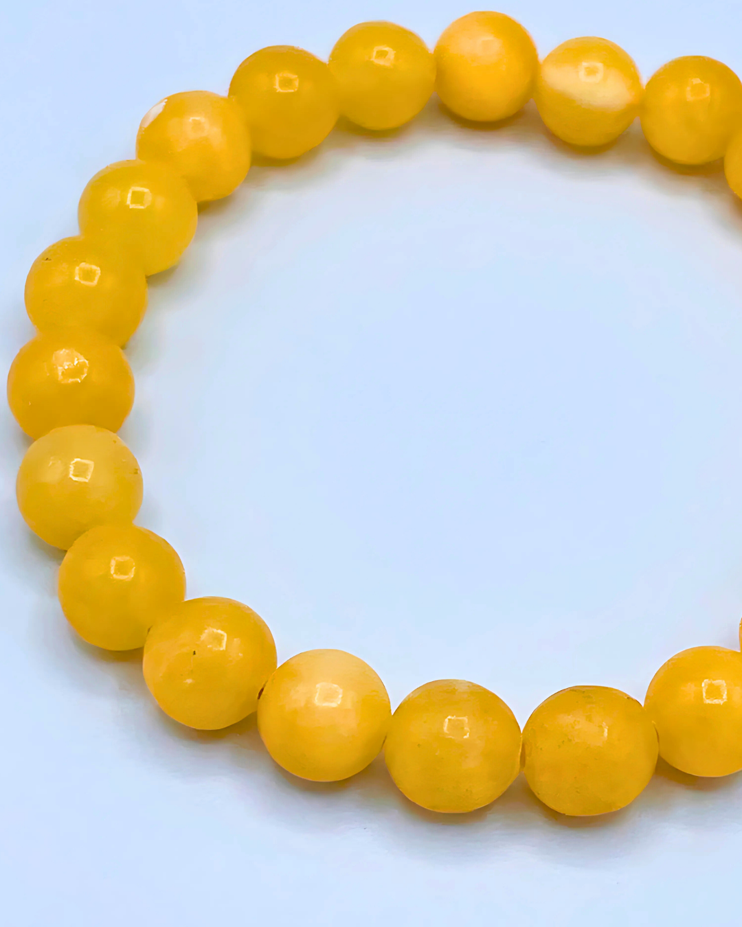 Yellow beaded bracelet on a light blue background