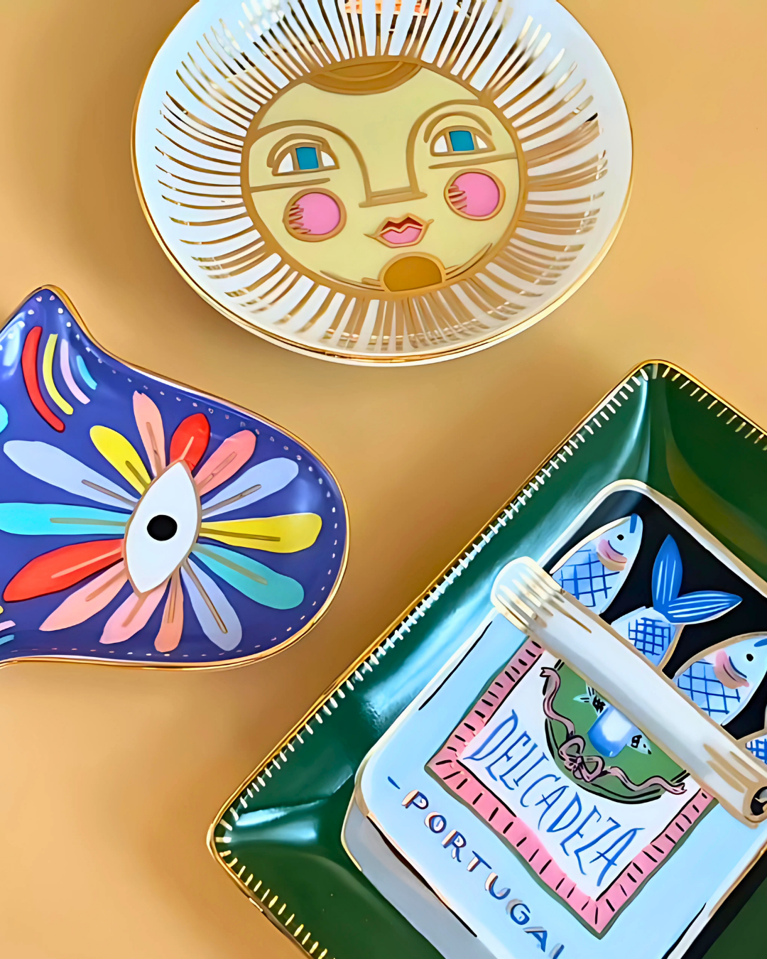 Colorful decorative items including a face plate, fish-shaped object, and a box with a pen on a gold background.