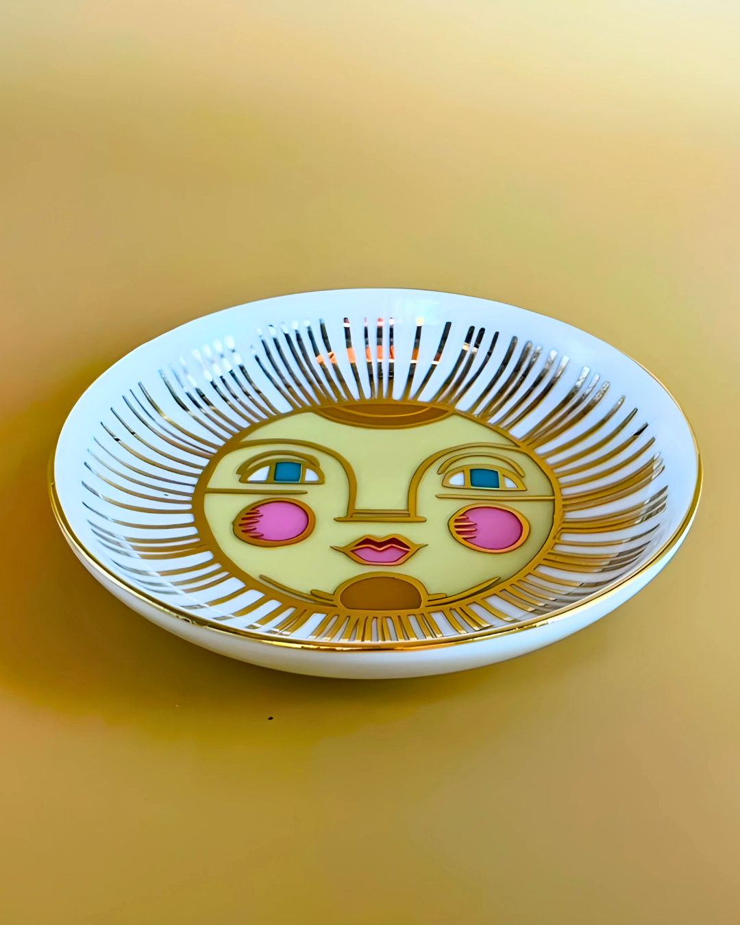 Decorative plate with a sun face design on a yellow background