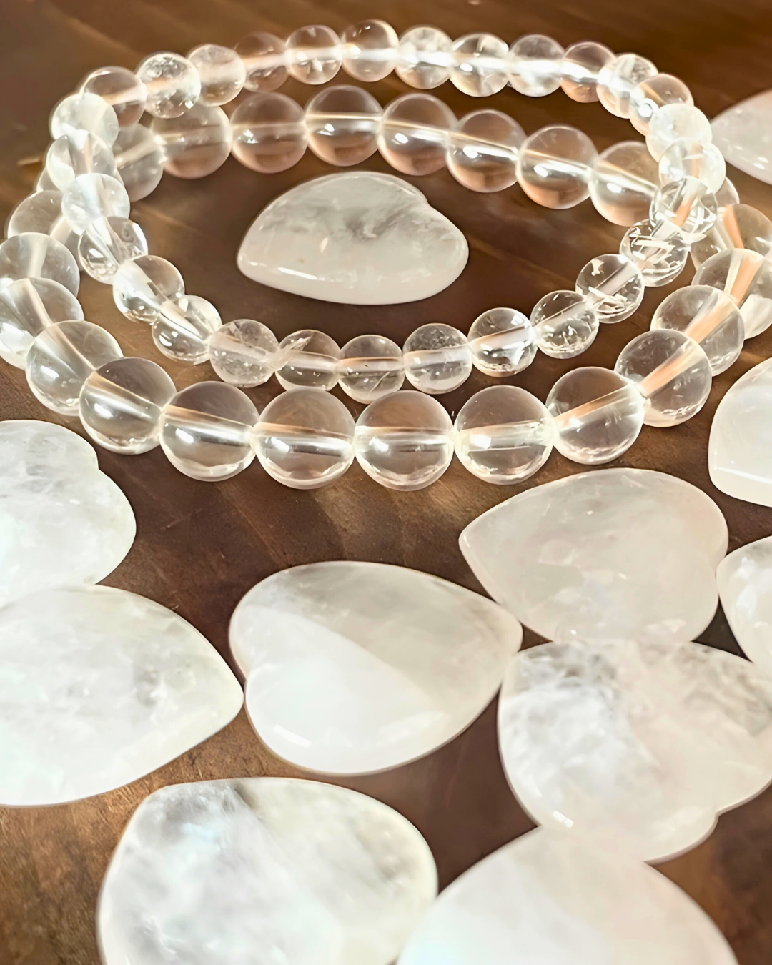 Clear beaded necklace with white stones on a wooden surface