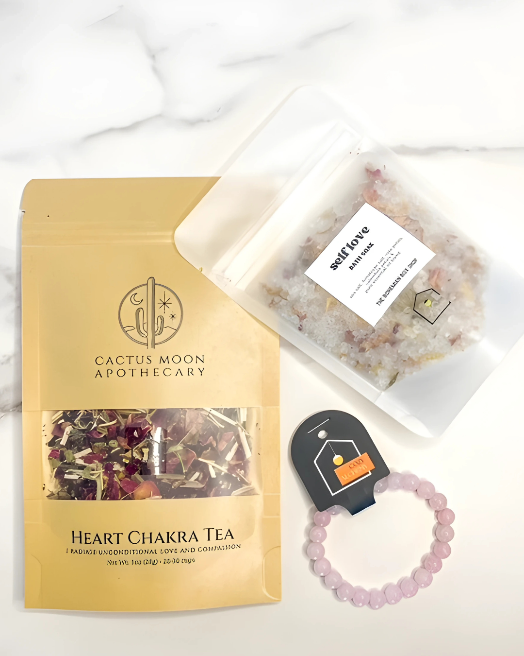 Cactus Moon Apothecary Heart Chakra Tea package with a bracelet and small bag on a white background