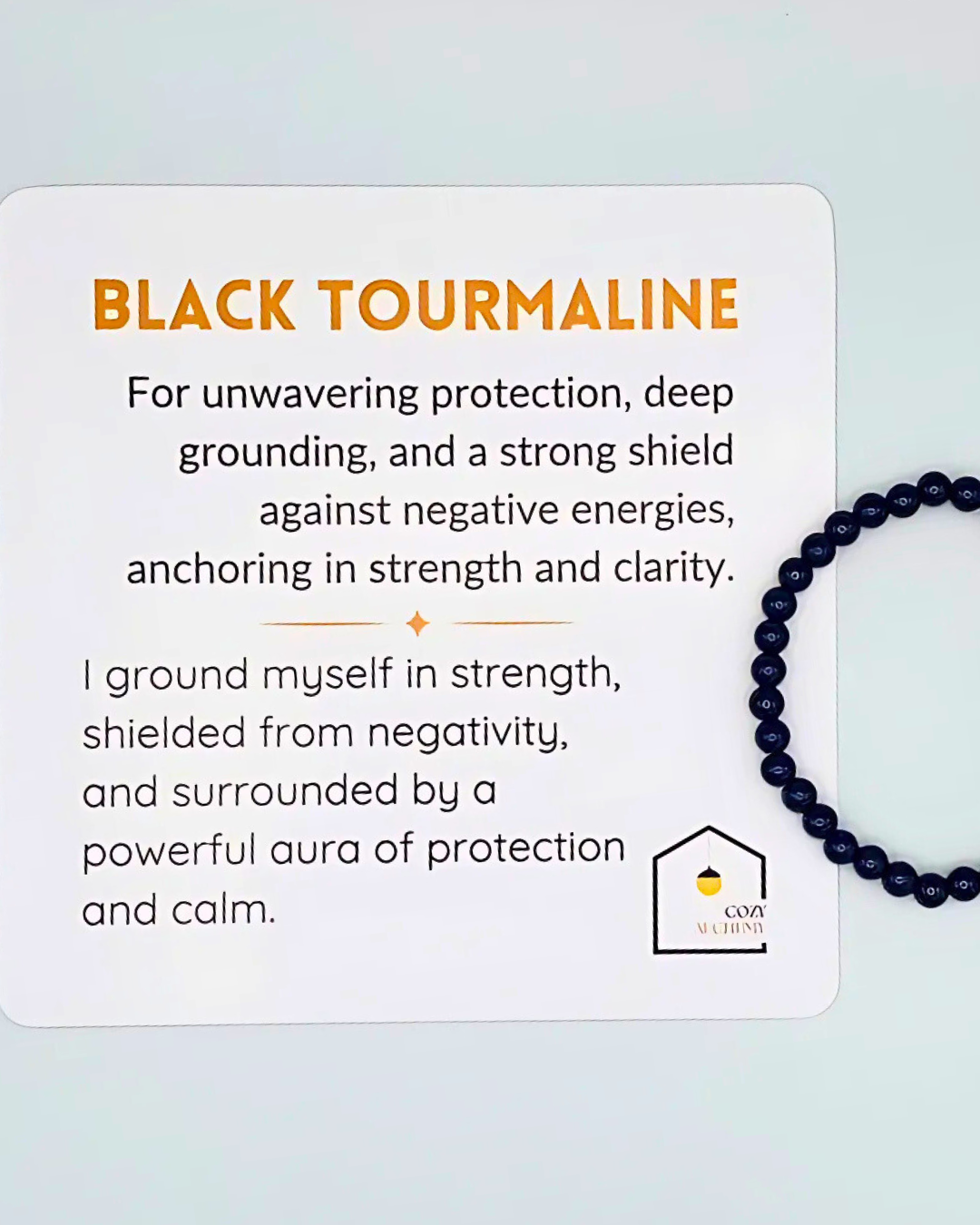 Black tourmaline bracelet with descriptive text on a light blue background