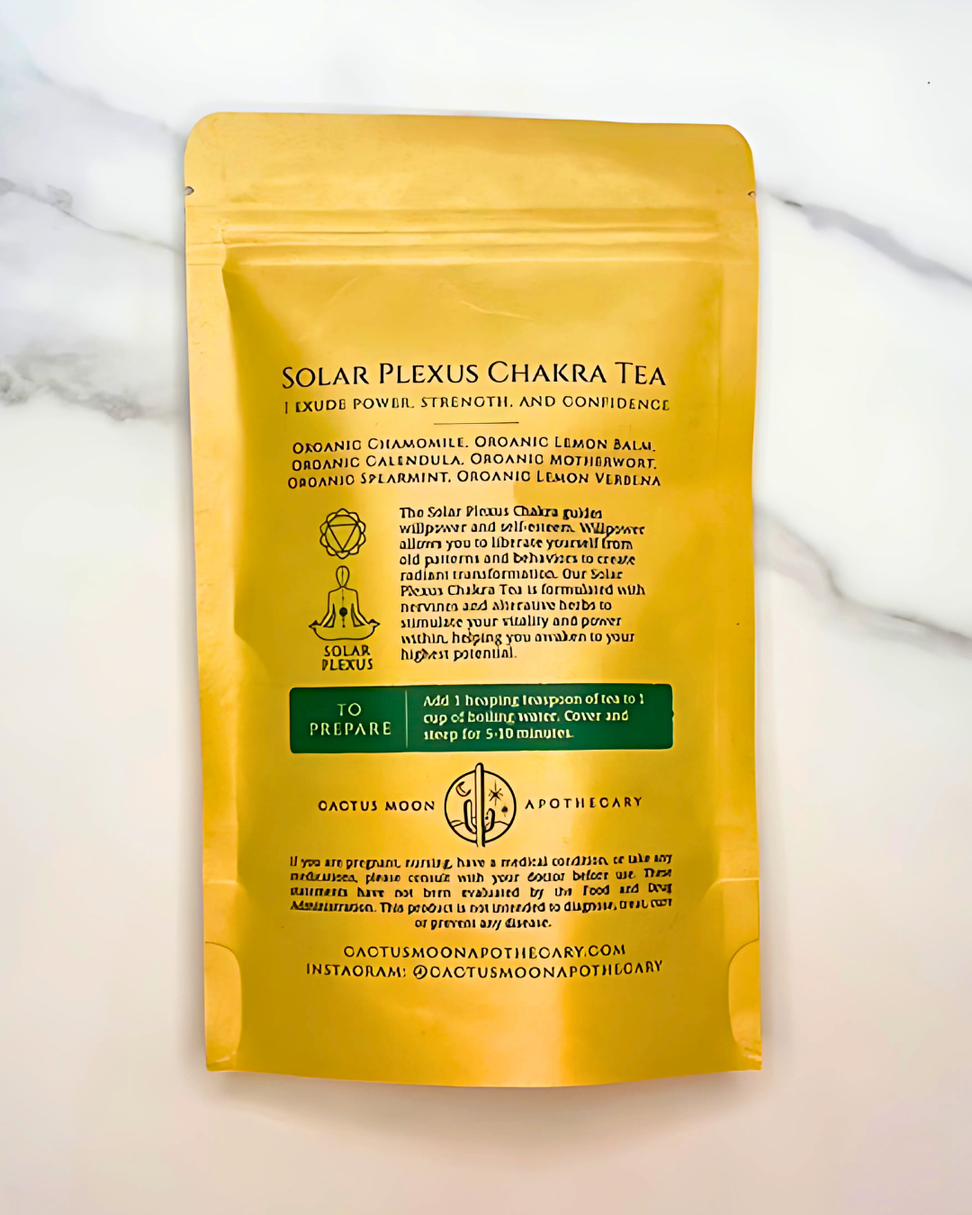 Yellow package of Solar Plexus Chakra Tea on a marble surface