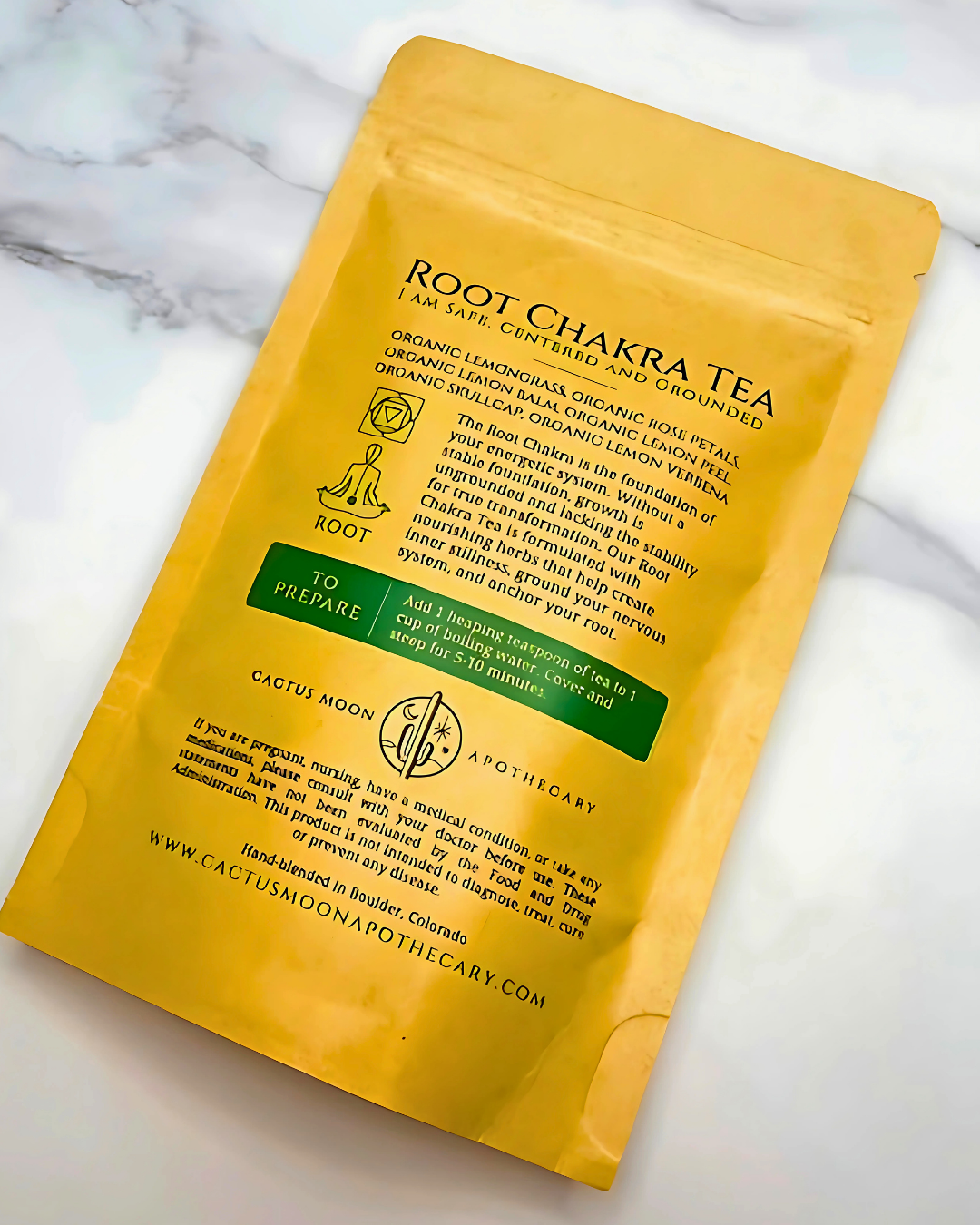 Yellow package of Root Chakra Tea with text on a marble surface