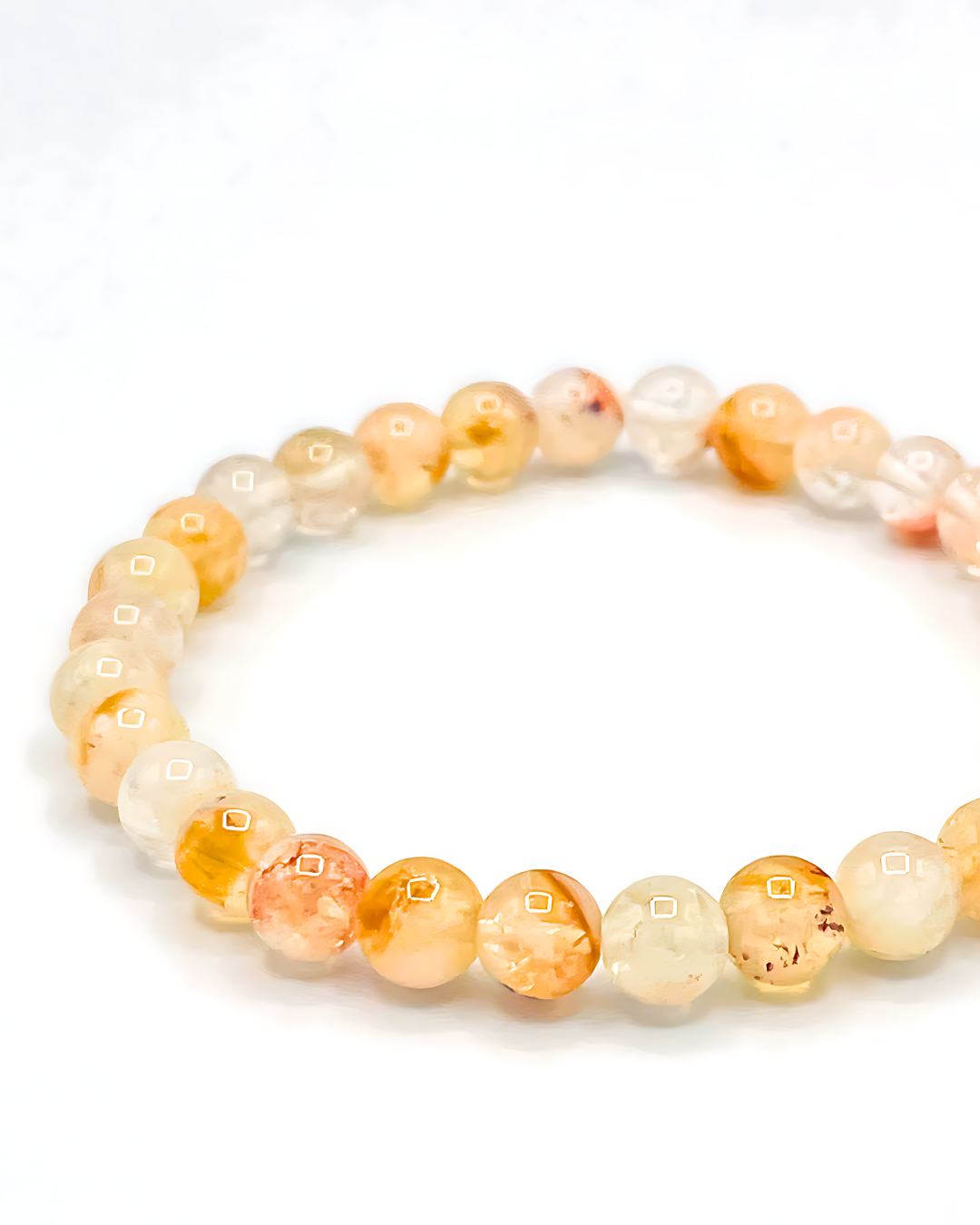 Beaded bracelet with orange and white beads on a white background