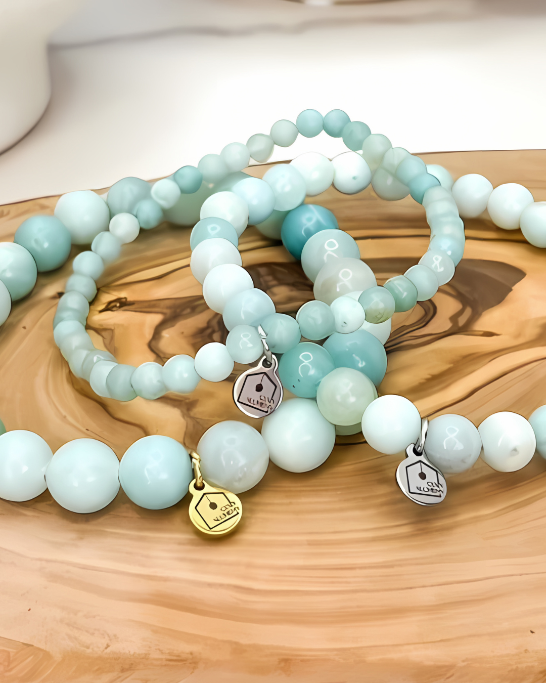 Set of beaded bracelets with charms on a wooden surface