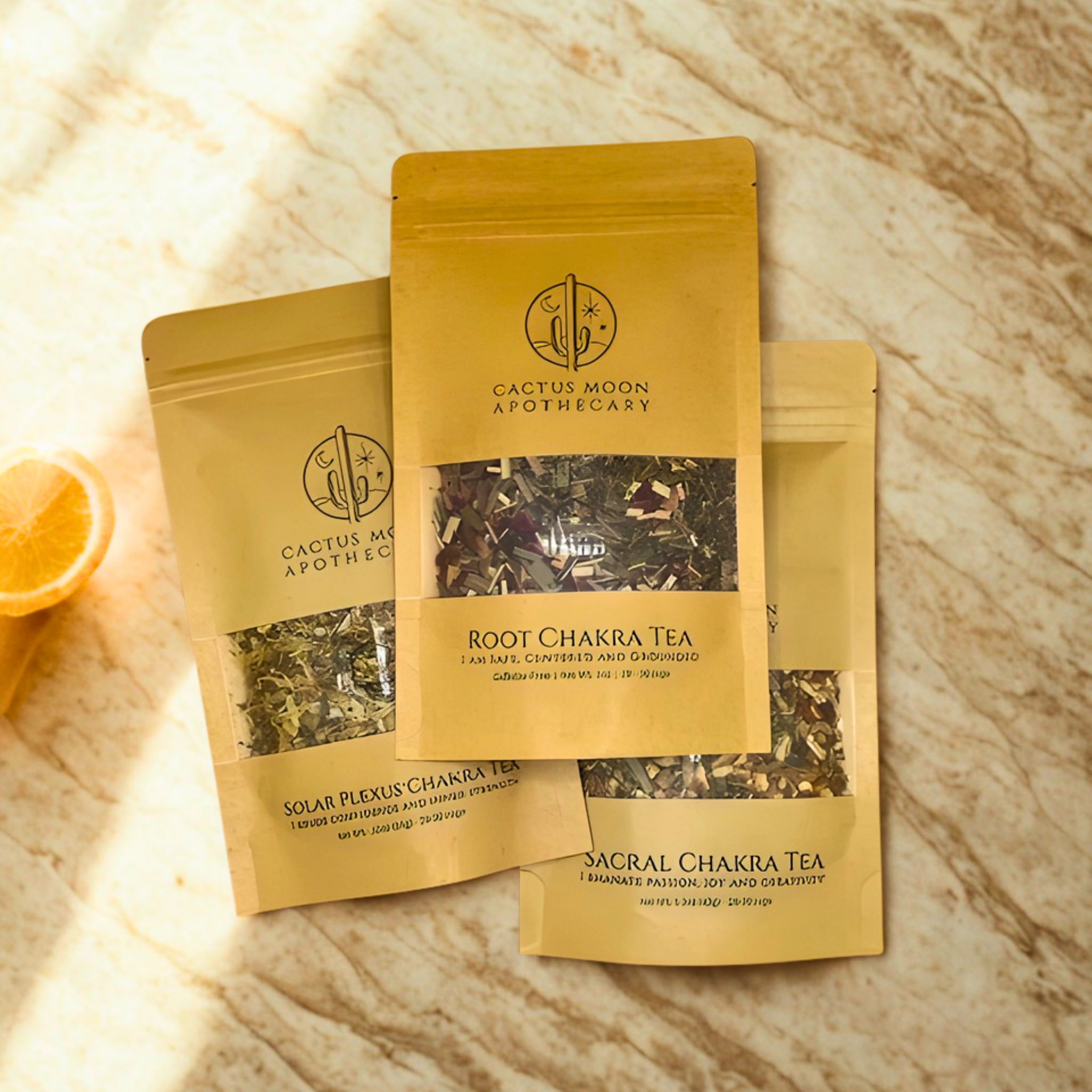 Three packages of Cactus Moon Apothecary chakra tea on a textured surface.