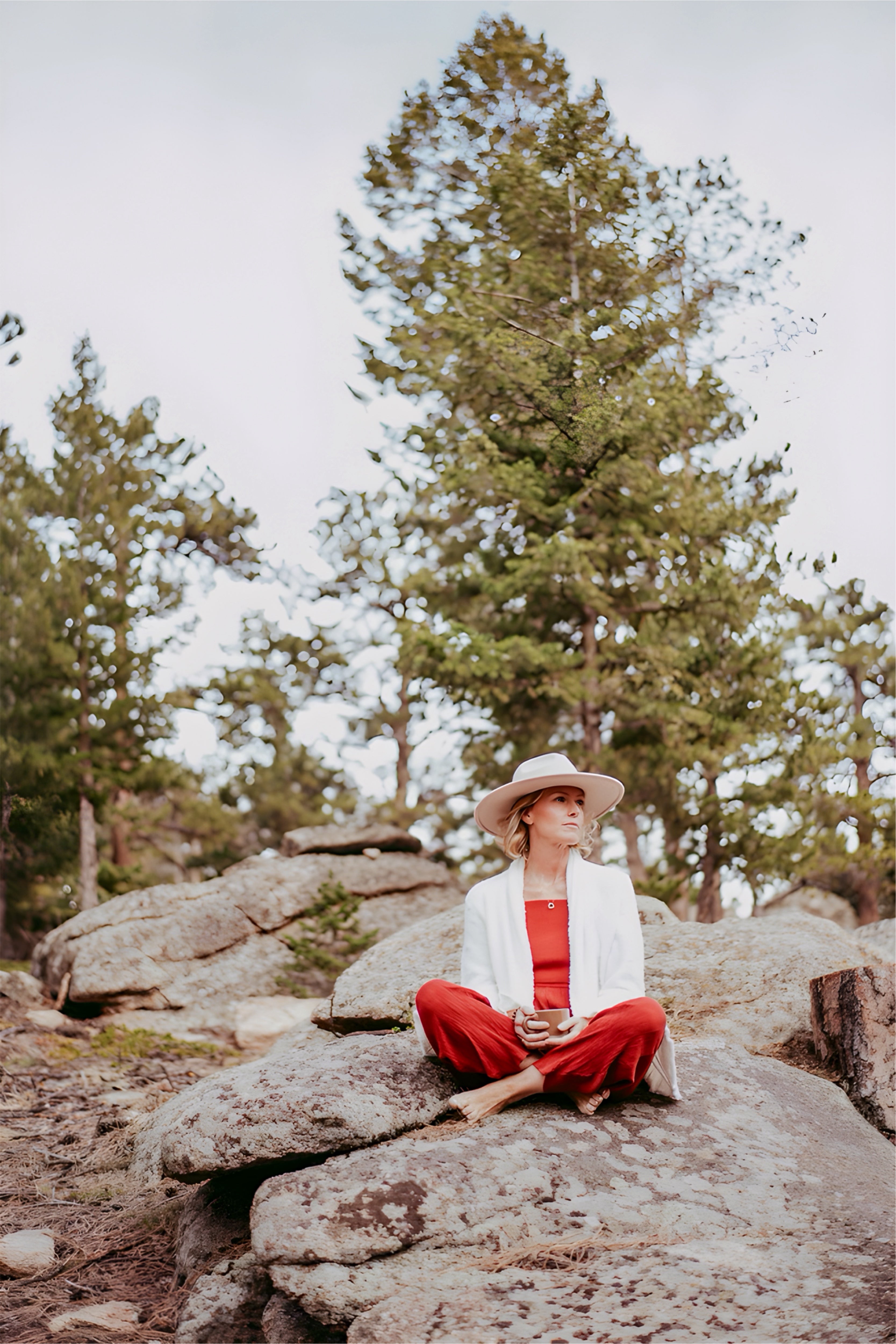 Woman sitting on a rock in a forested area
