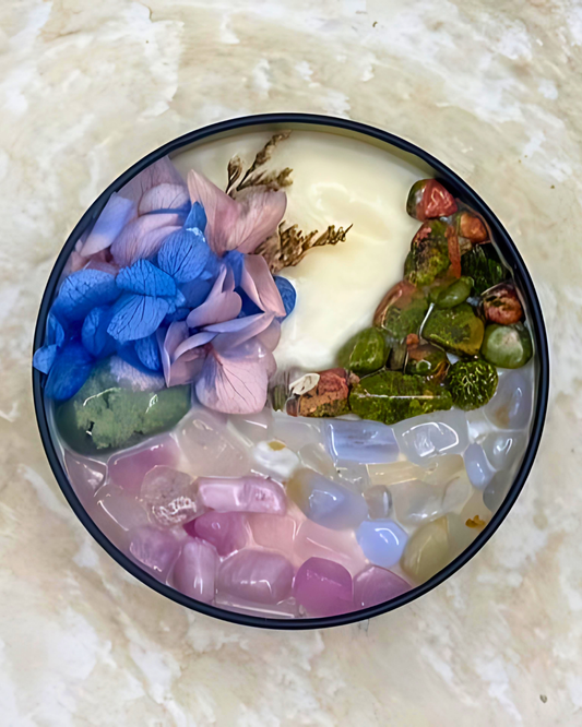 Decorative dish with colorful stones and flowers on a textured surface