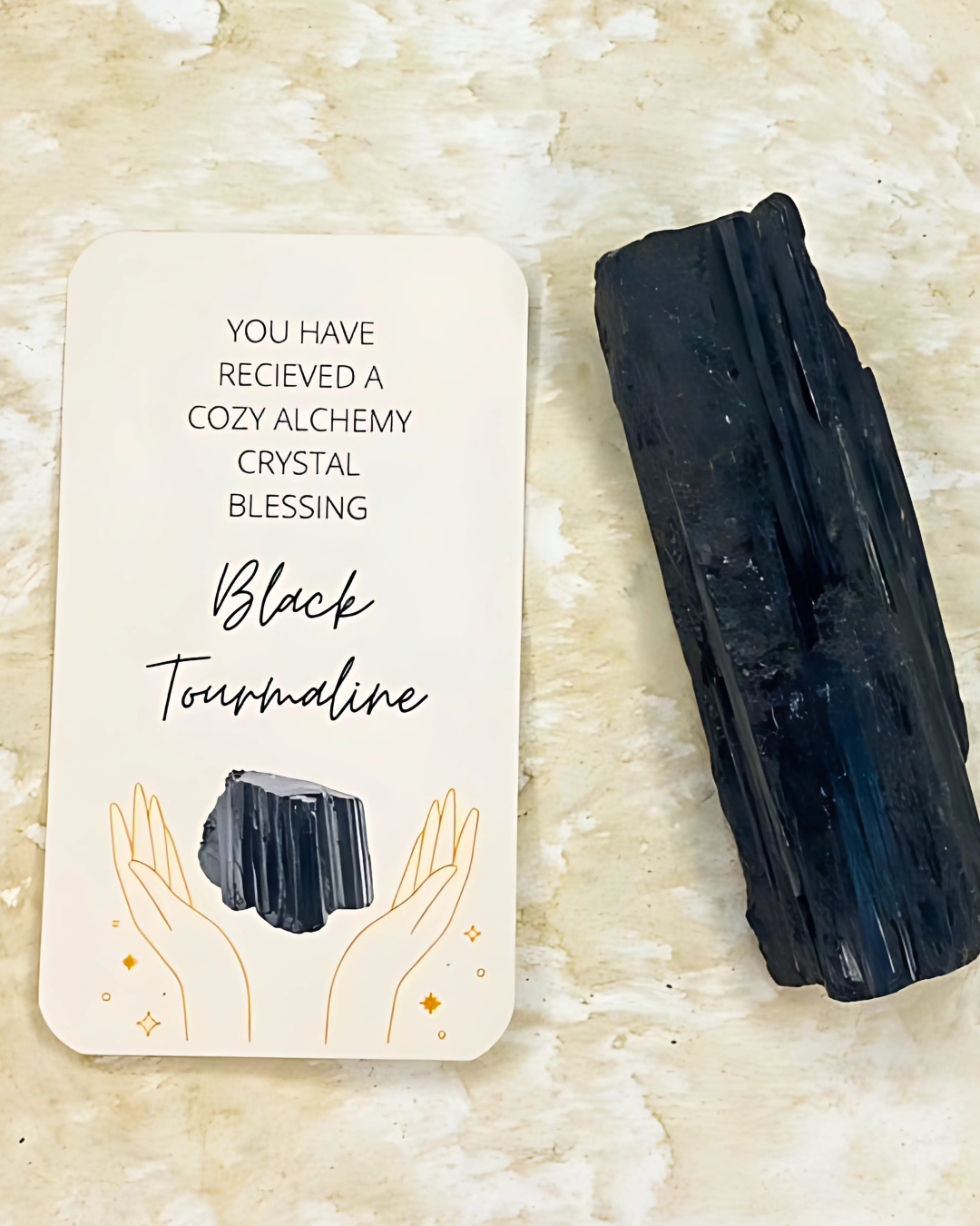 Black tourmaline crystal with a card on a beige background