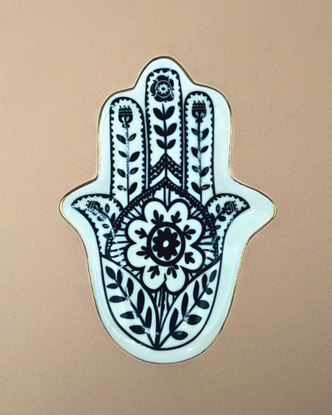 Decorative Hamsa hand with floral patterns on a beige background