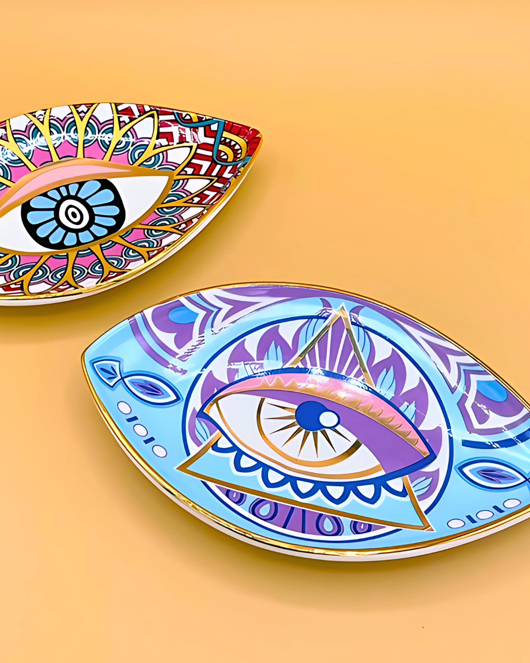 Two decorative plates with eye designs on a yellow background