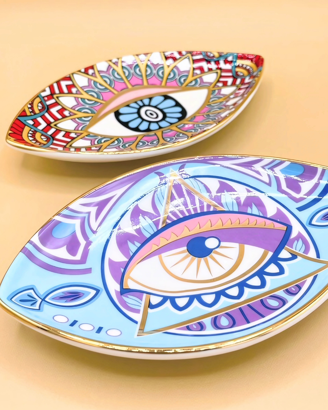 Two decorative plates with eye designs on a beige background