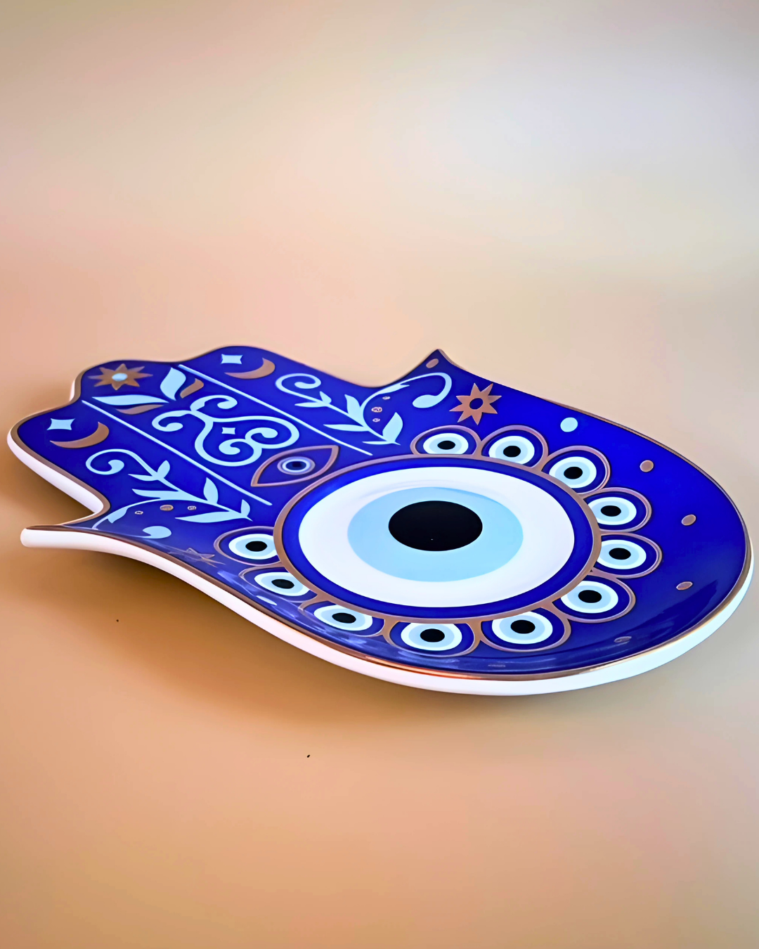 Decorative Hamsa hand plate with blue and white design on a beige background