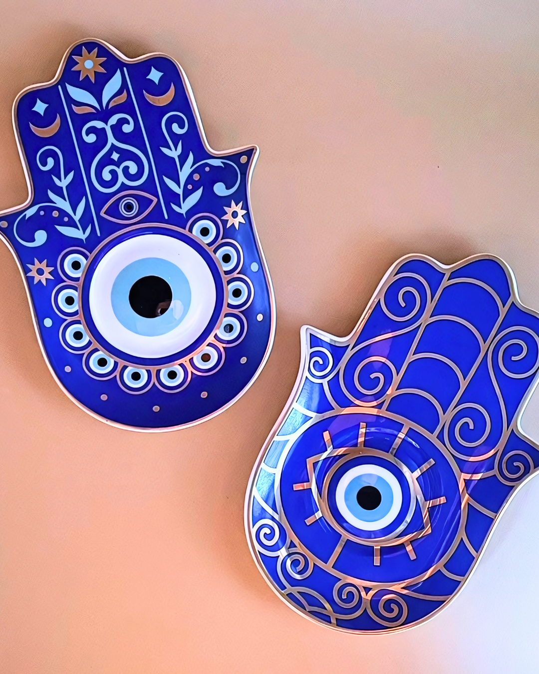 Two blue Hamsa hand pins with eye design on a gradient background