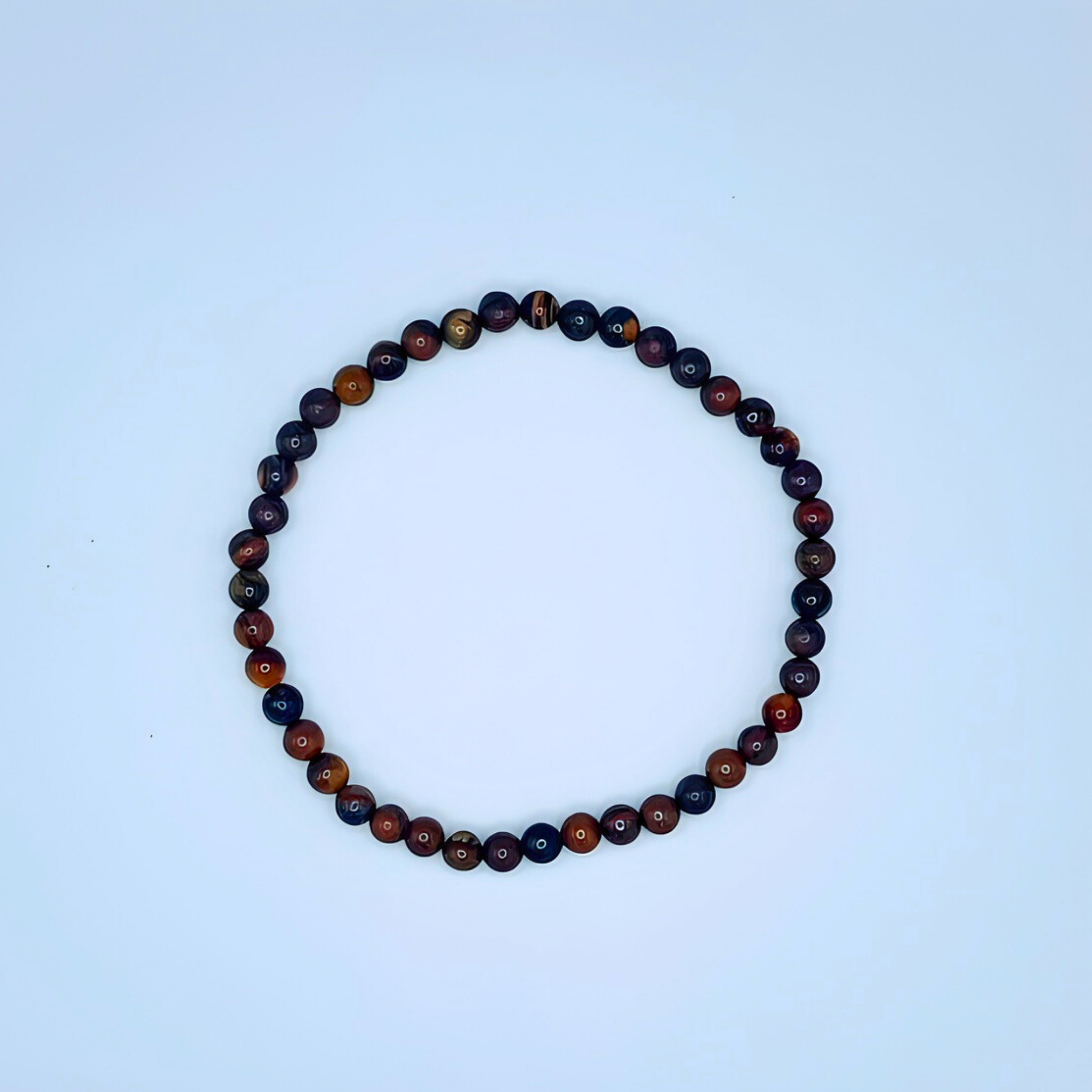 Roundel of multicolored beads on a light blue background