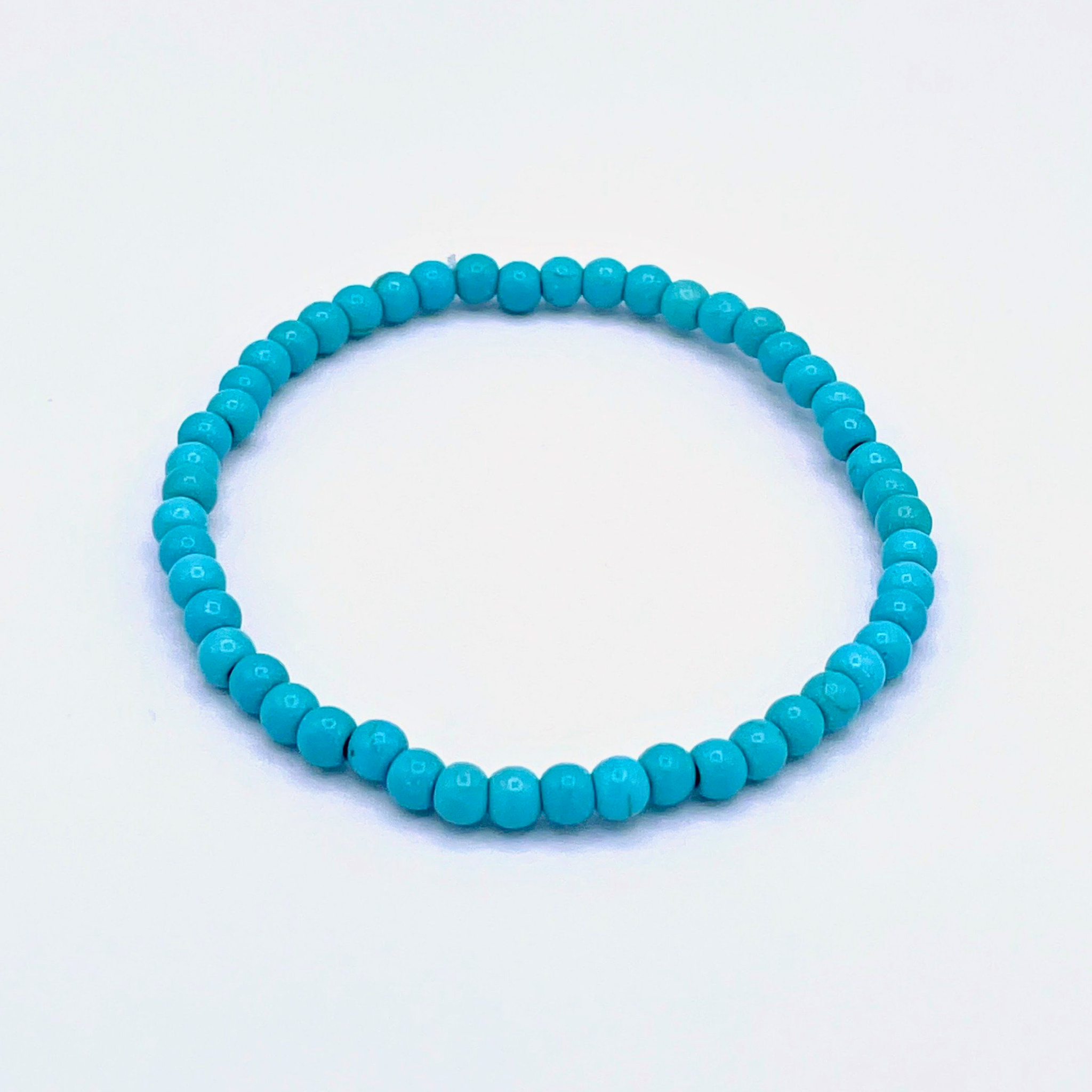 Turquoise beaded bracelet on a light blue background