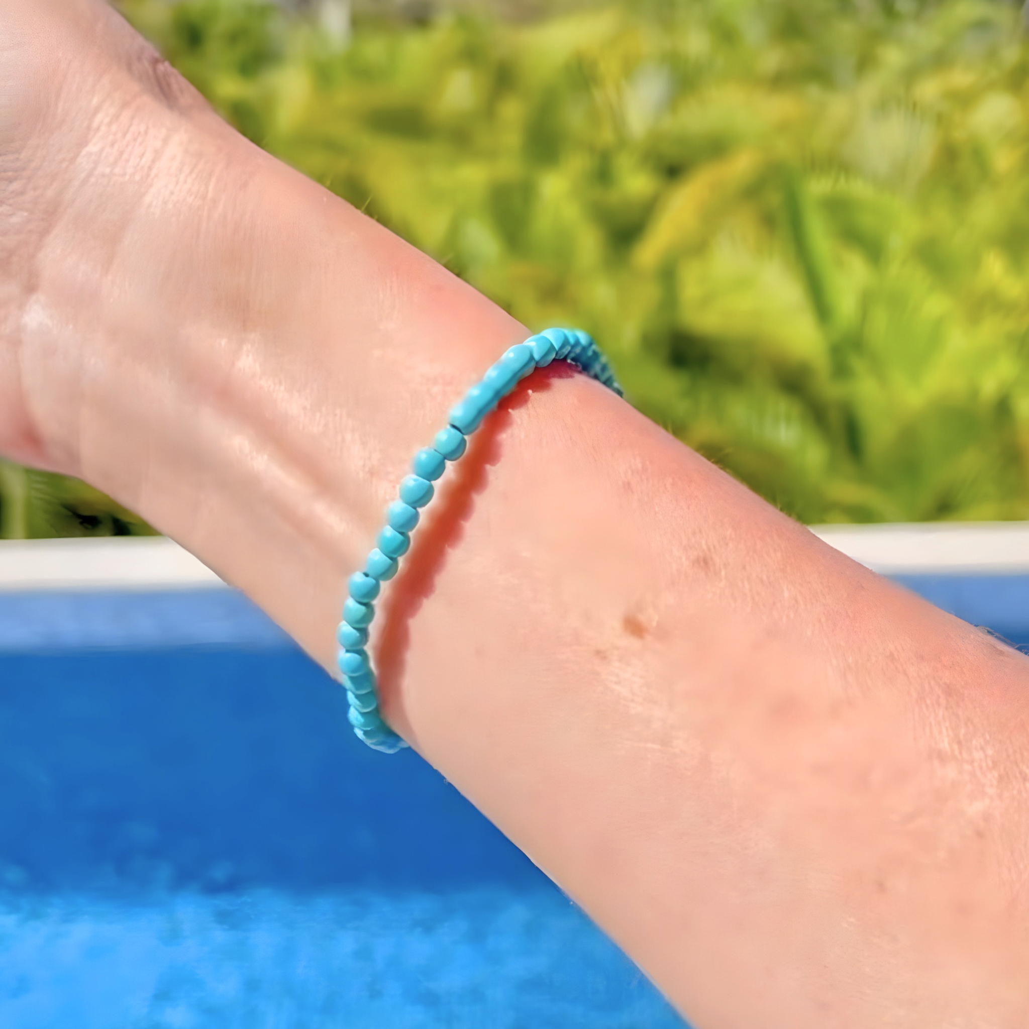 Turquoise bracelet on a wrist with a blurred natural background