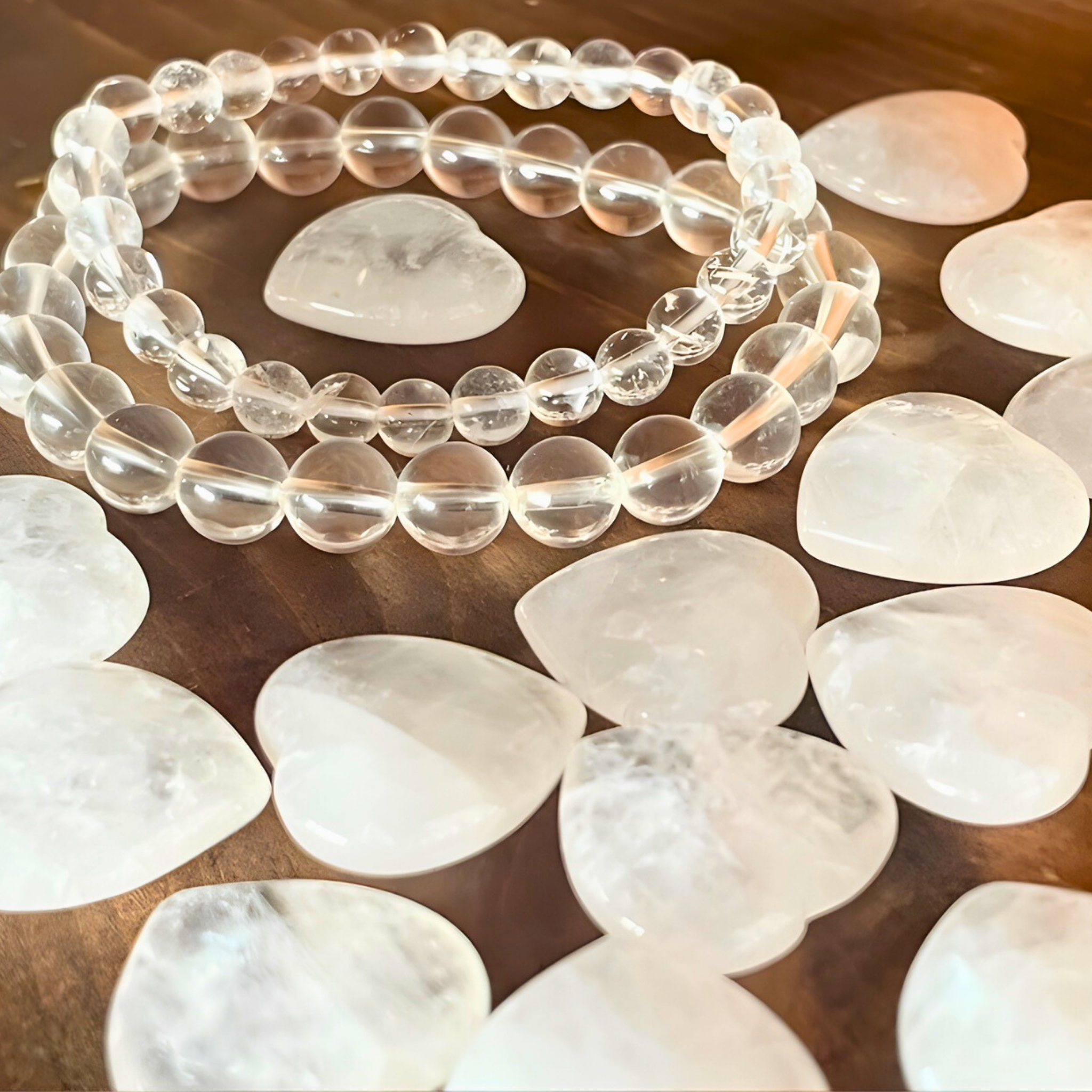 Clear beaded bracelet on a wooden surface with white stones