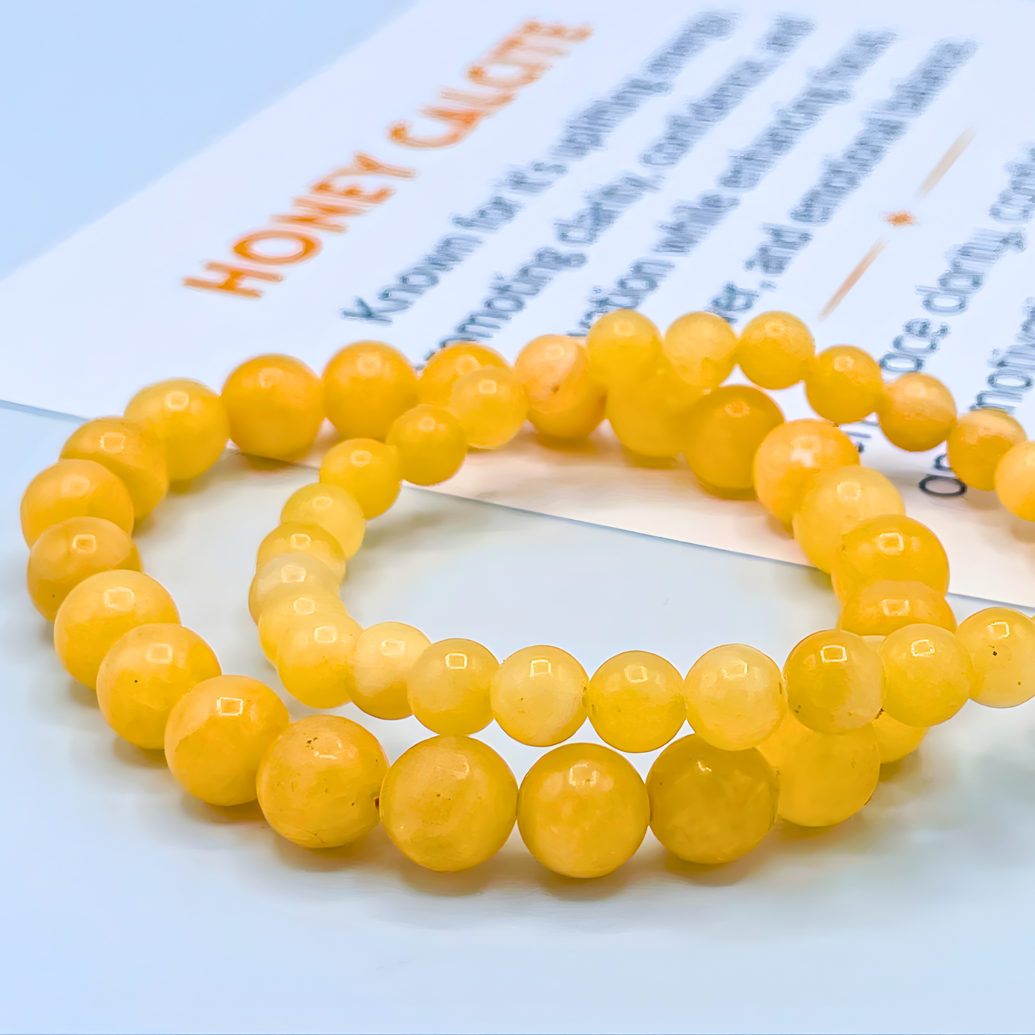 Yellow beaded bracelet on a piece of paper with text