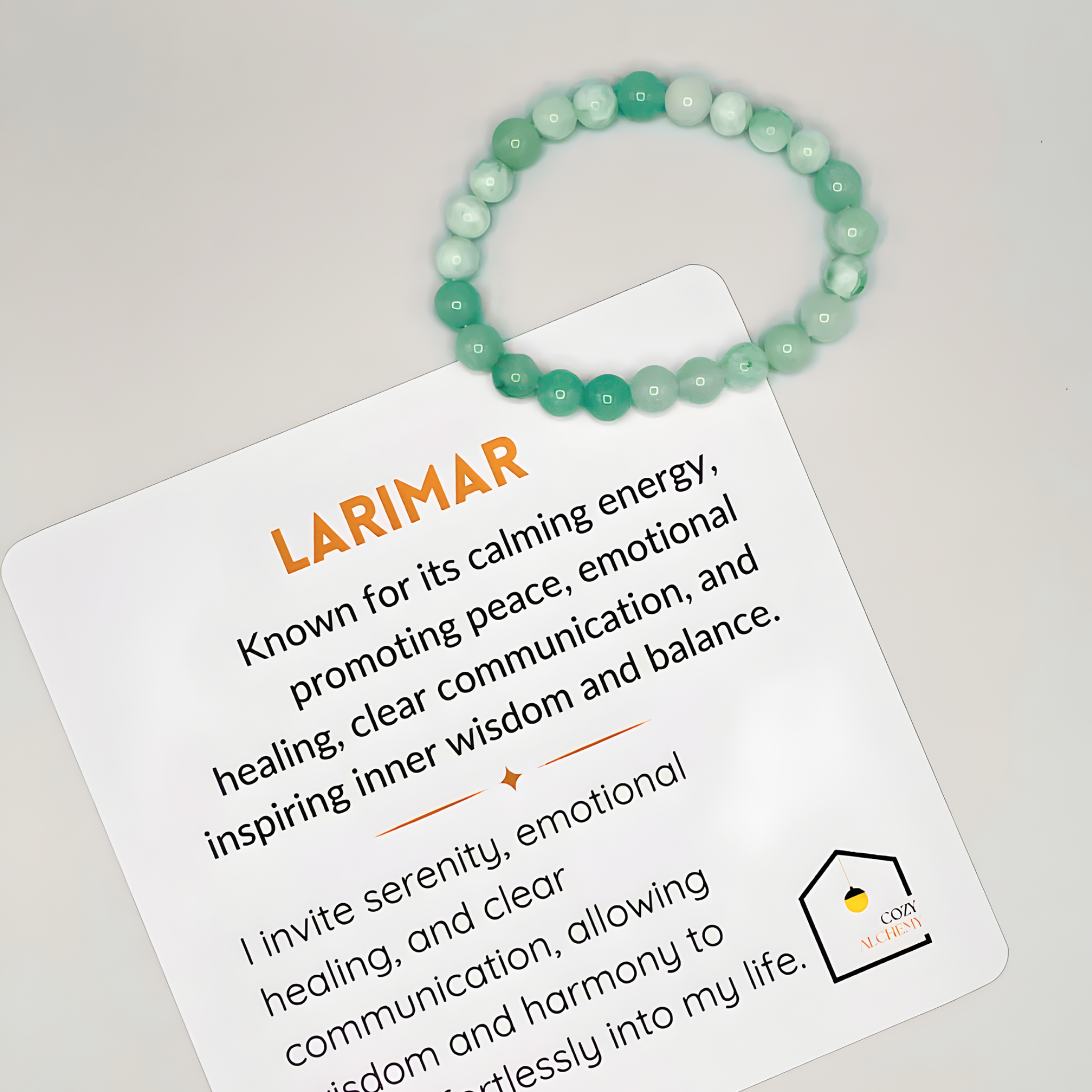Green larimar bracelet on a card with information about larimar stone properties.
