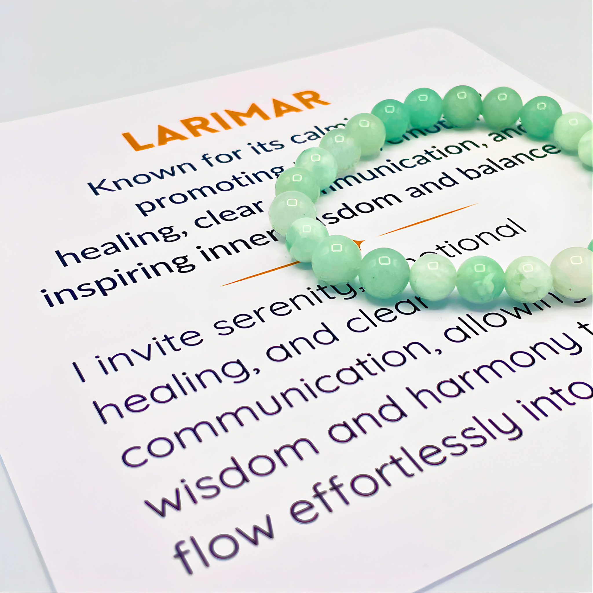 Green beaded bracelet on a piece of paper with text about larimar stone properties.
