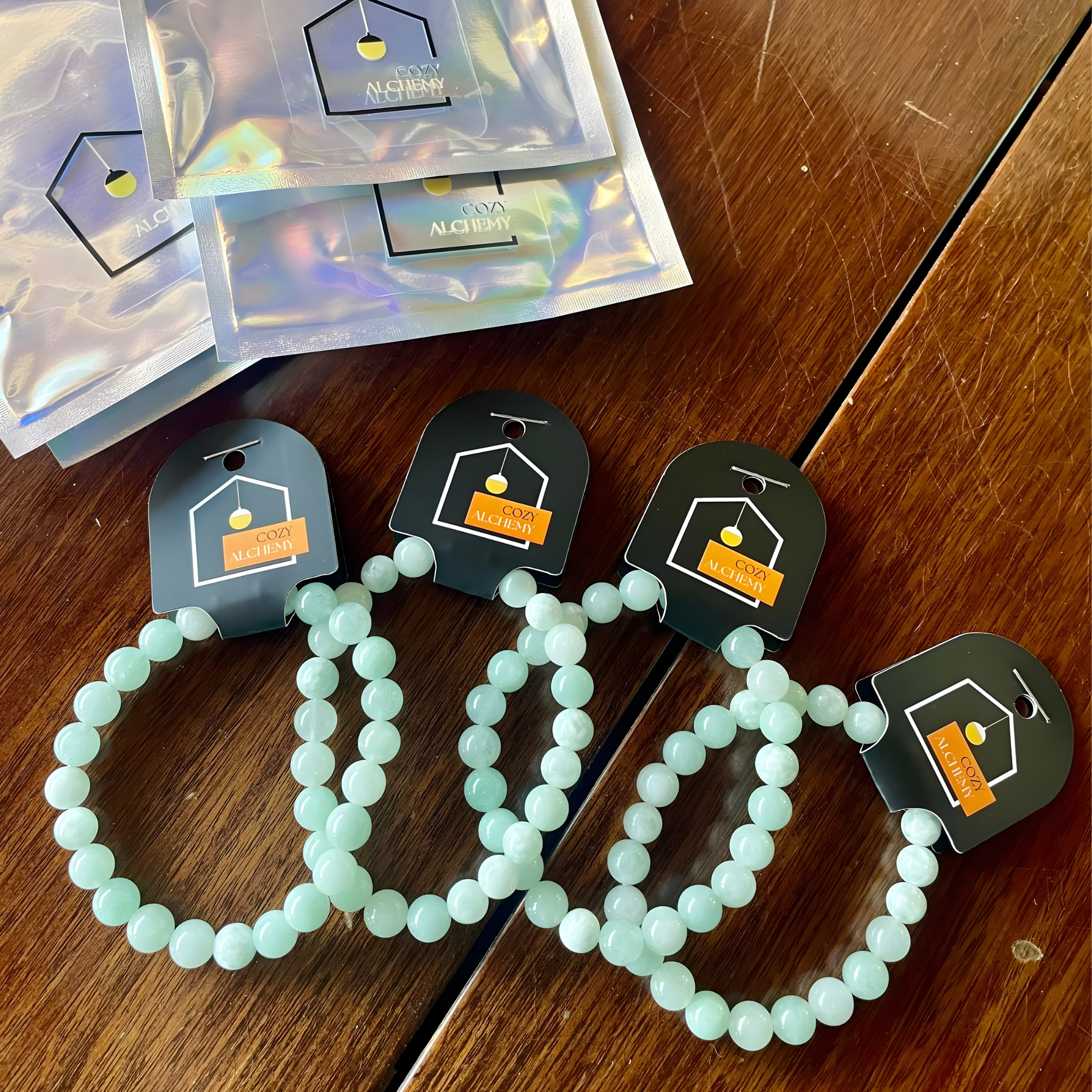 Mint Larimer crystal beaded bracelets on wooden surface with branded cards