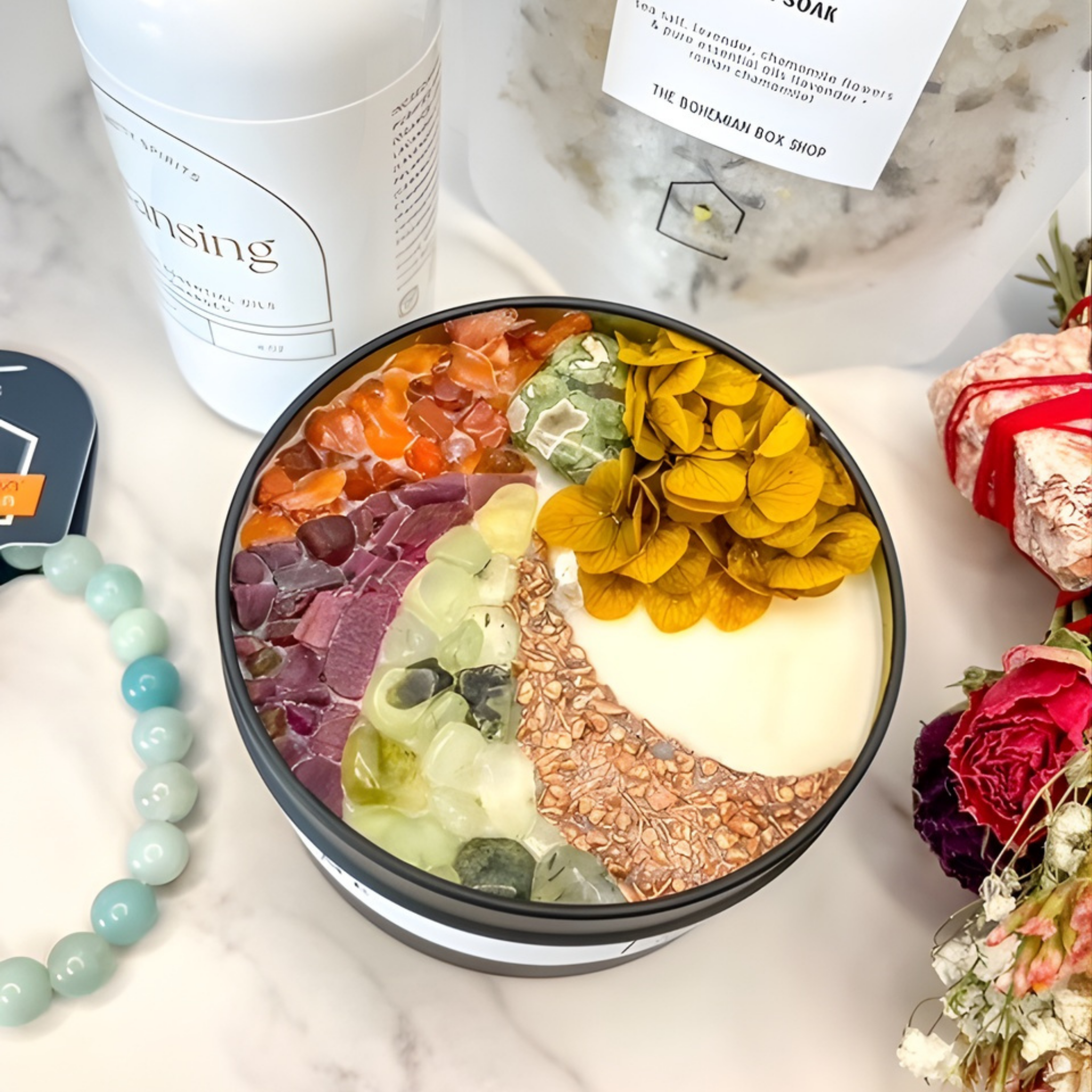 Colorful acai bowl with various toppings on a marble surface, featuring a jar of 'Sensing' and decorative elements.