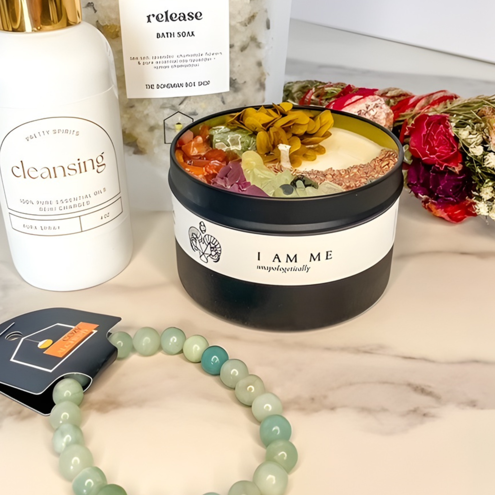 Bath product with flowers, 'I AM ME' label, and 'cleansing' soap on a marble surface.