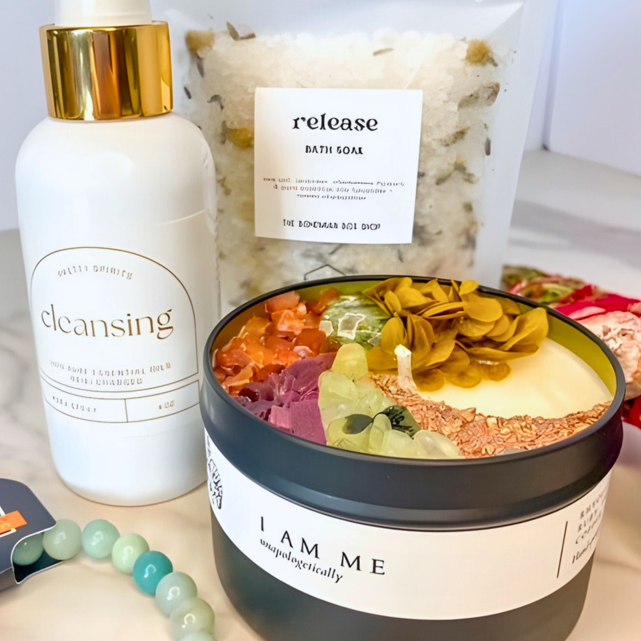 Bath products including a bottle labeled 'cleansing', a bag labeled 'release bath soap', and a container labeled 'I AM ME' on a light background.