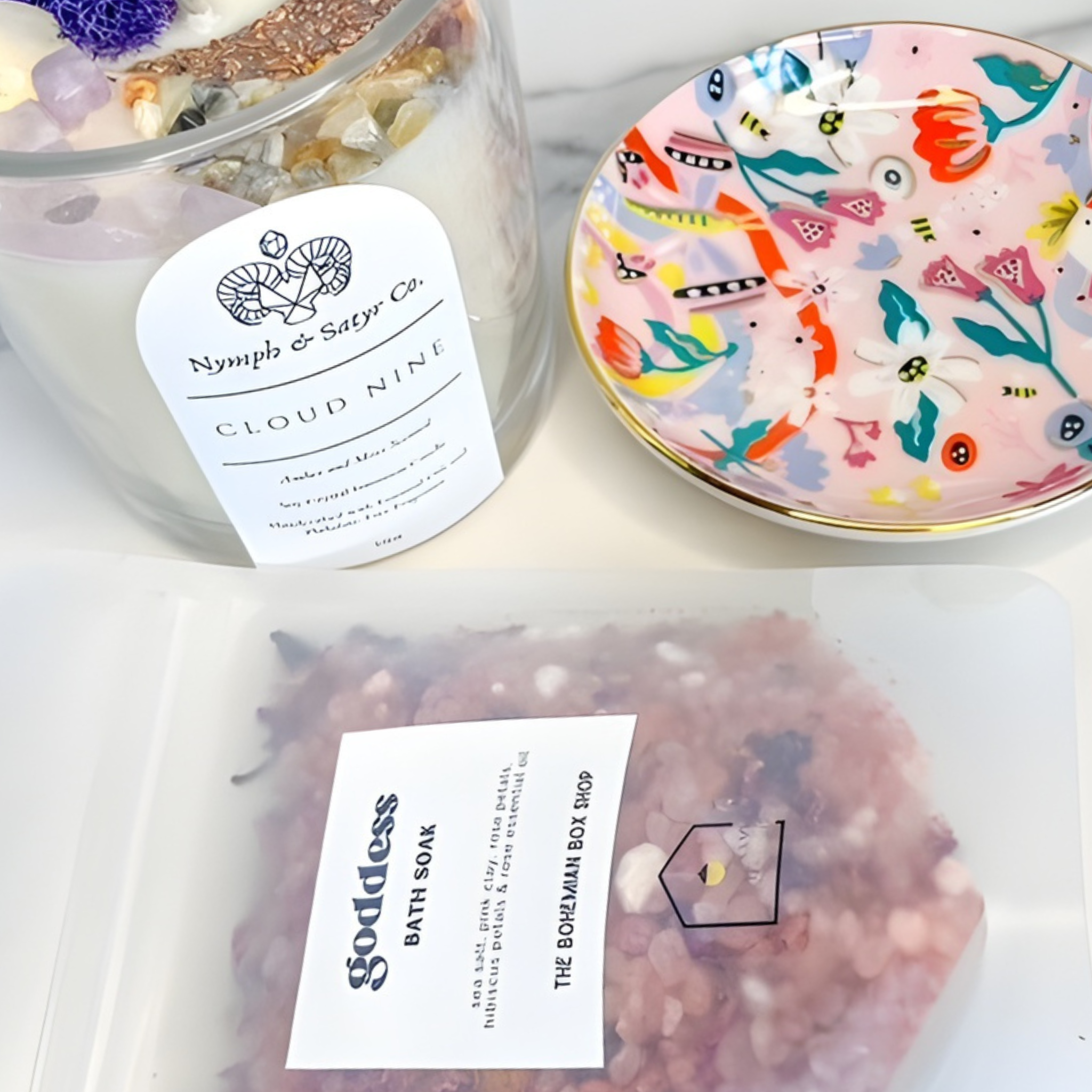Candle labeled 'Cloud Nine' by Nymph & Satyr Co. with a decorative dish and bath soap packaging.