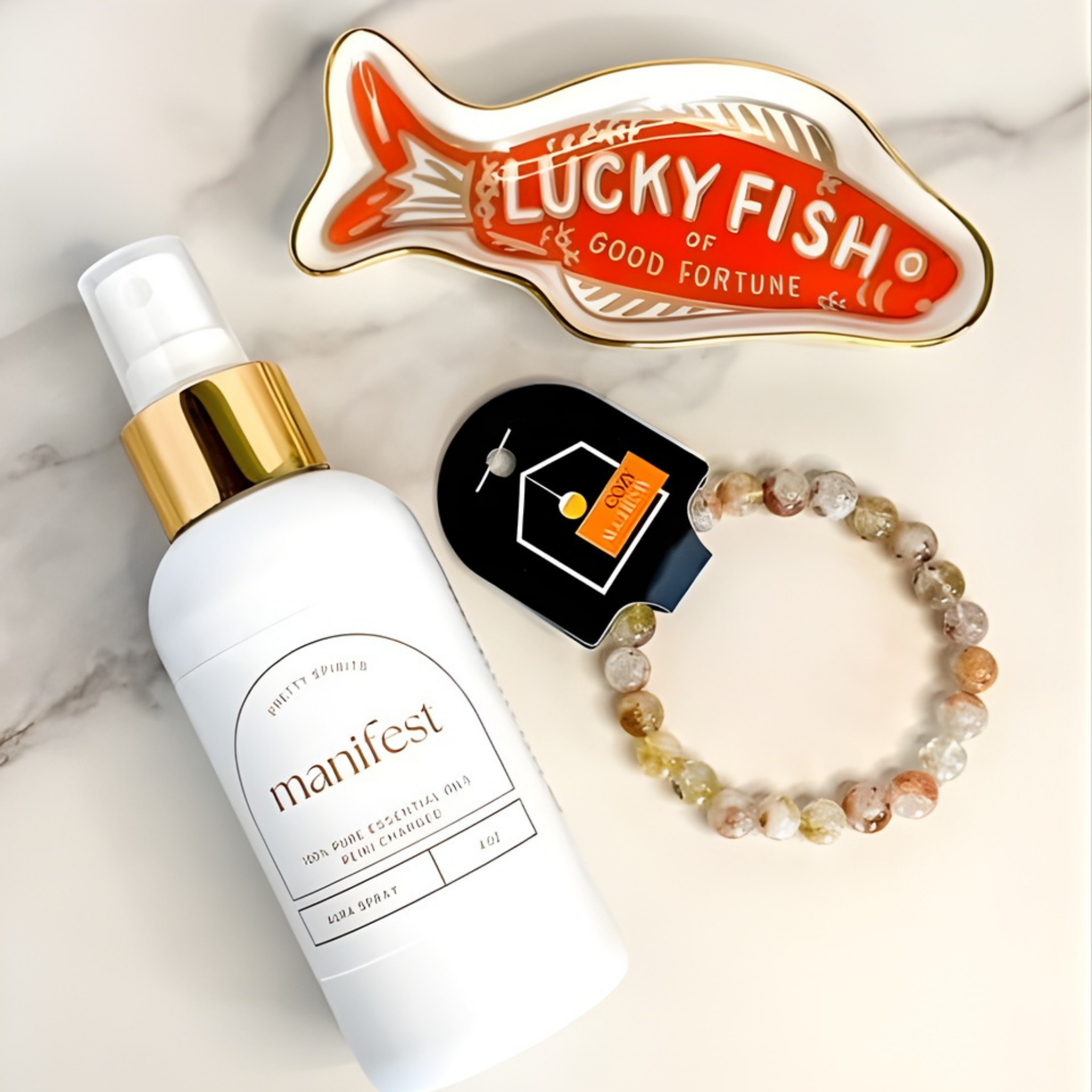 Manifest skincare product, Lucky Fish of Good Fortune ornament, and beaded bracelet on a marble surface