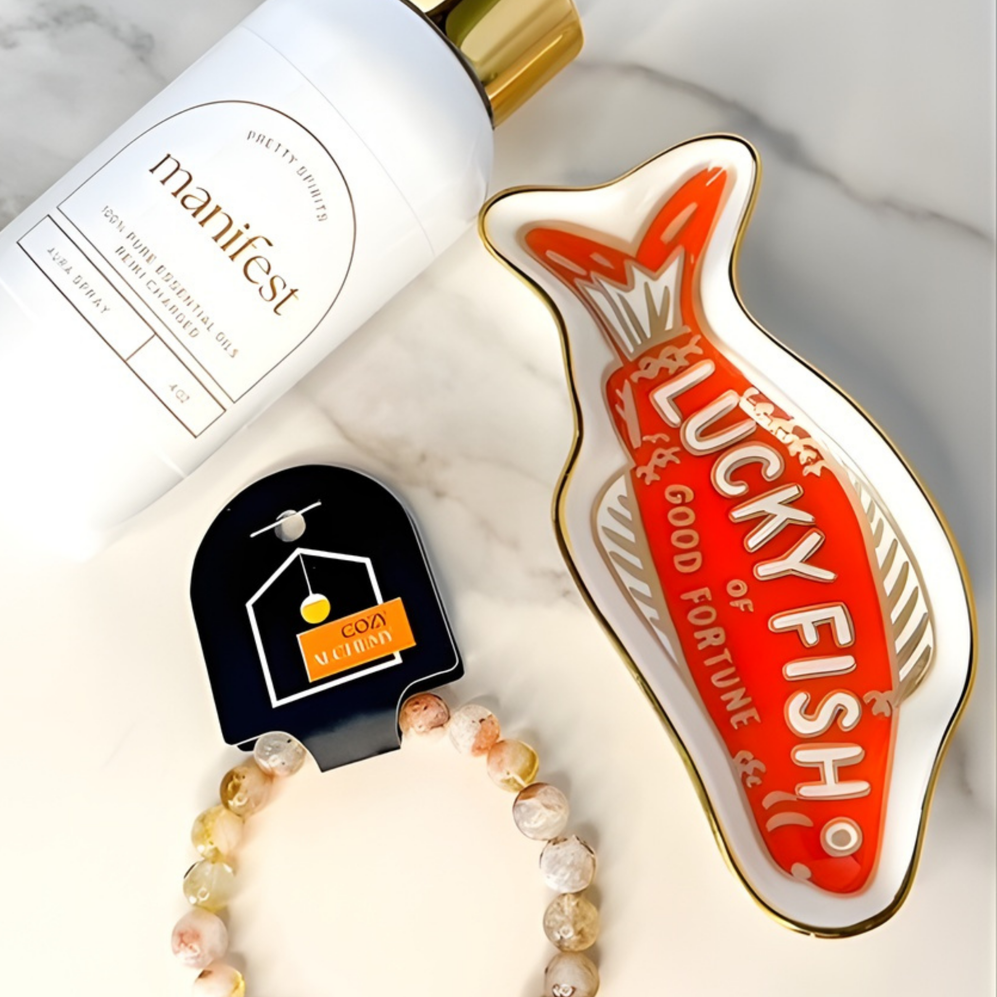 Manifest bottle, Lucky Fisho product, and bracelet on a marble surface