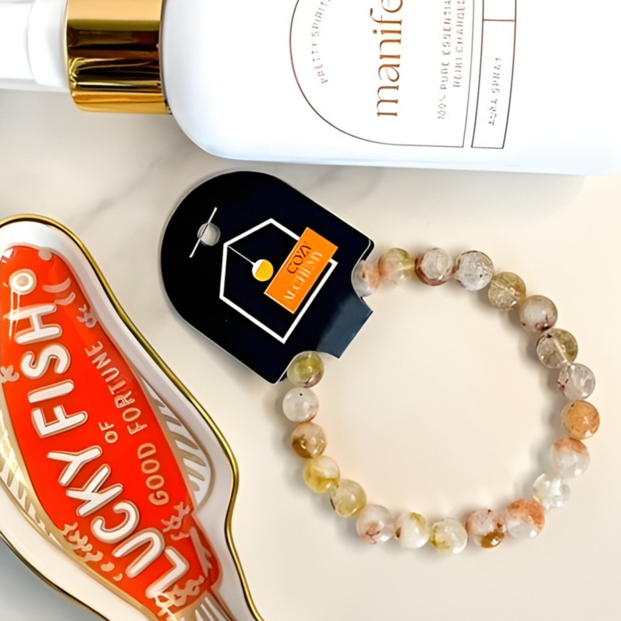 Beaded bracelet, Lucky Fish product, and Manify bottle on a white surface