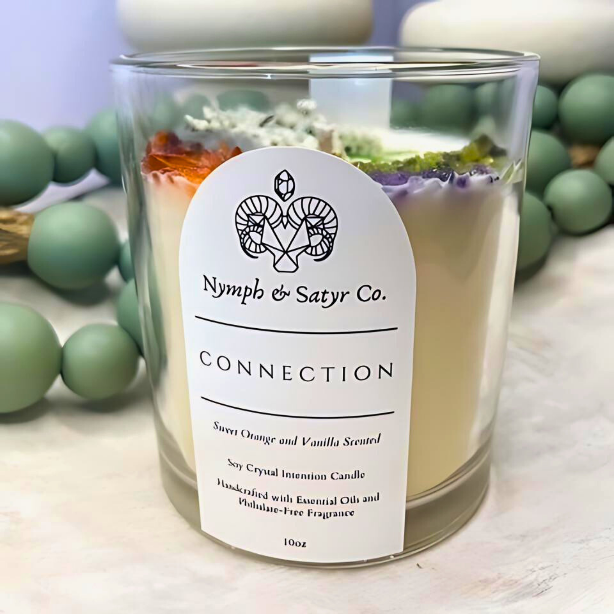 scented candle with flowers and crystals in clear jar