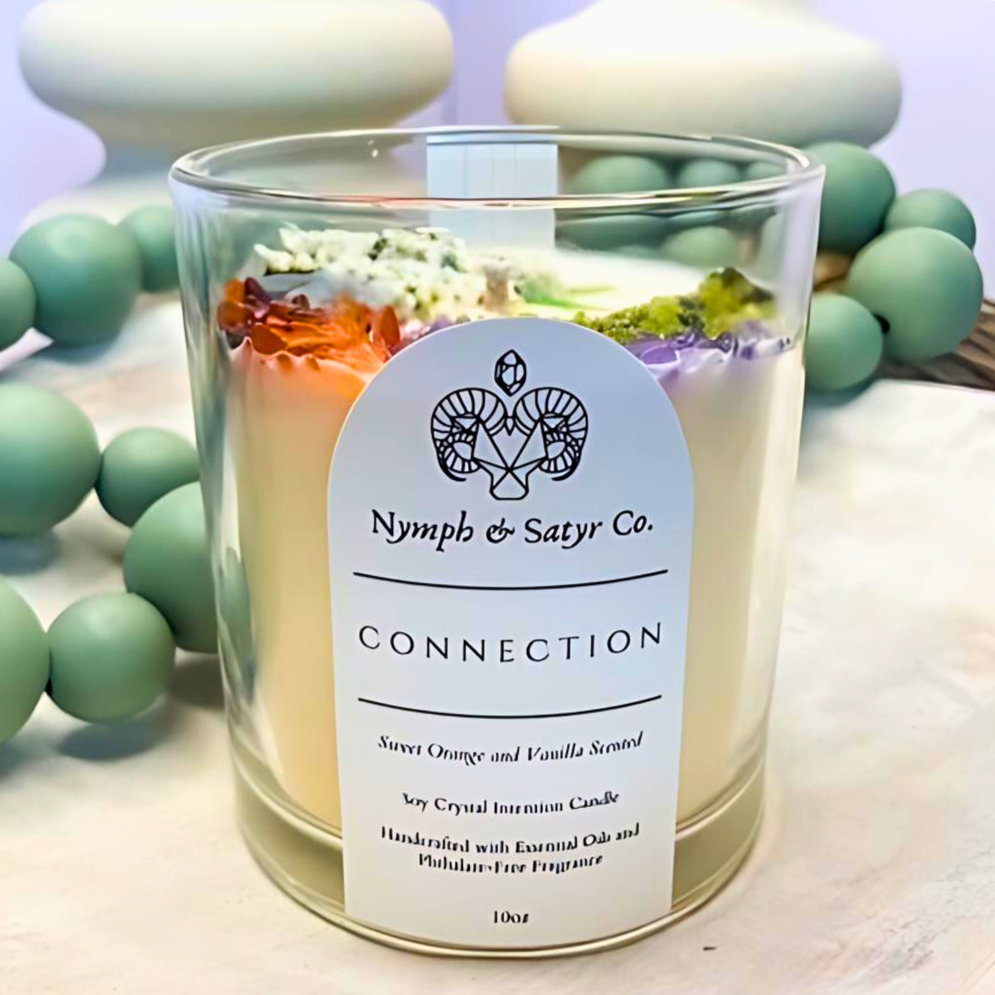 scented candle with flowers and crystals in black jar