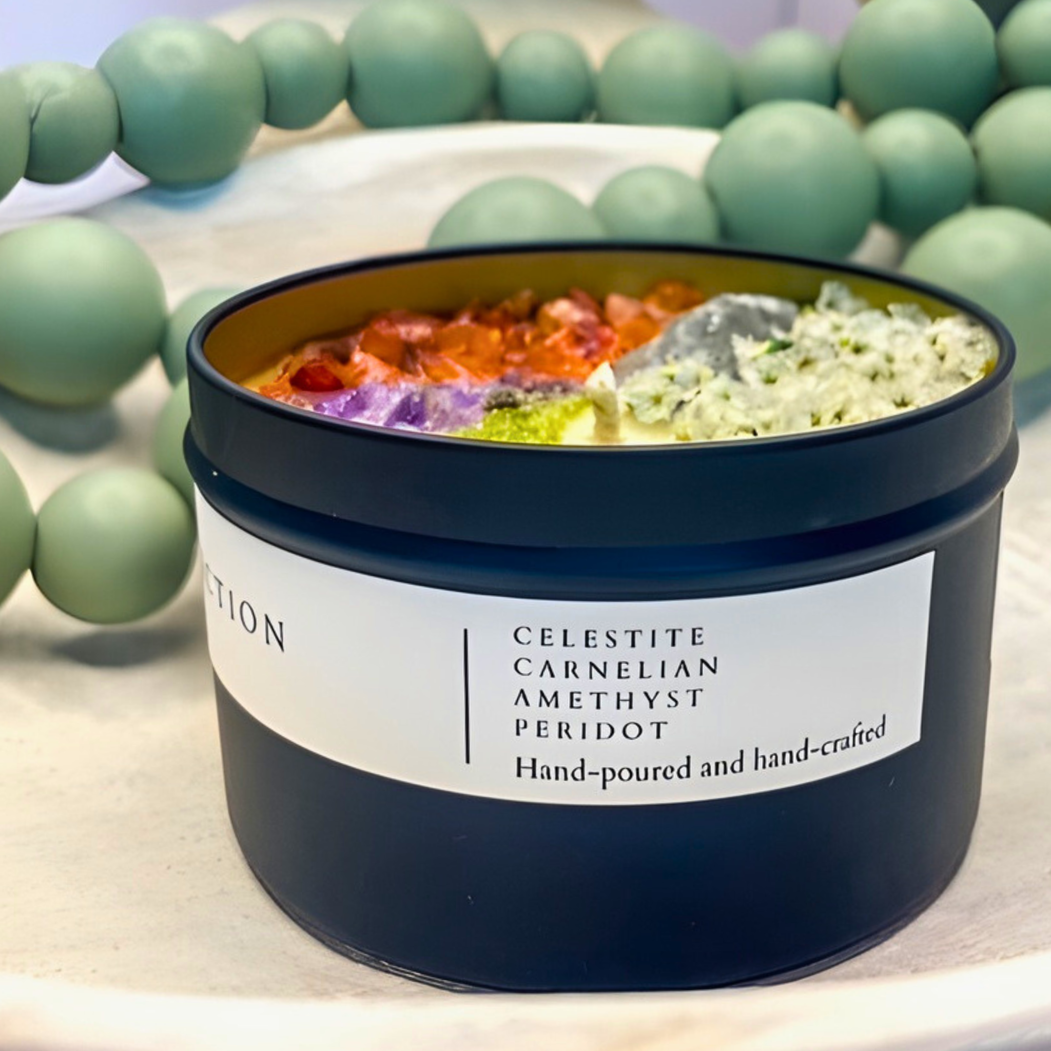 scented candle with flowers and crystals in black jar