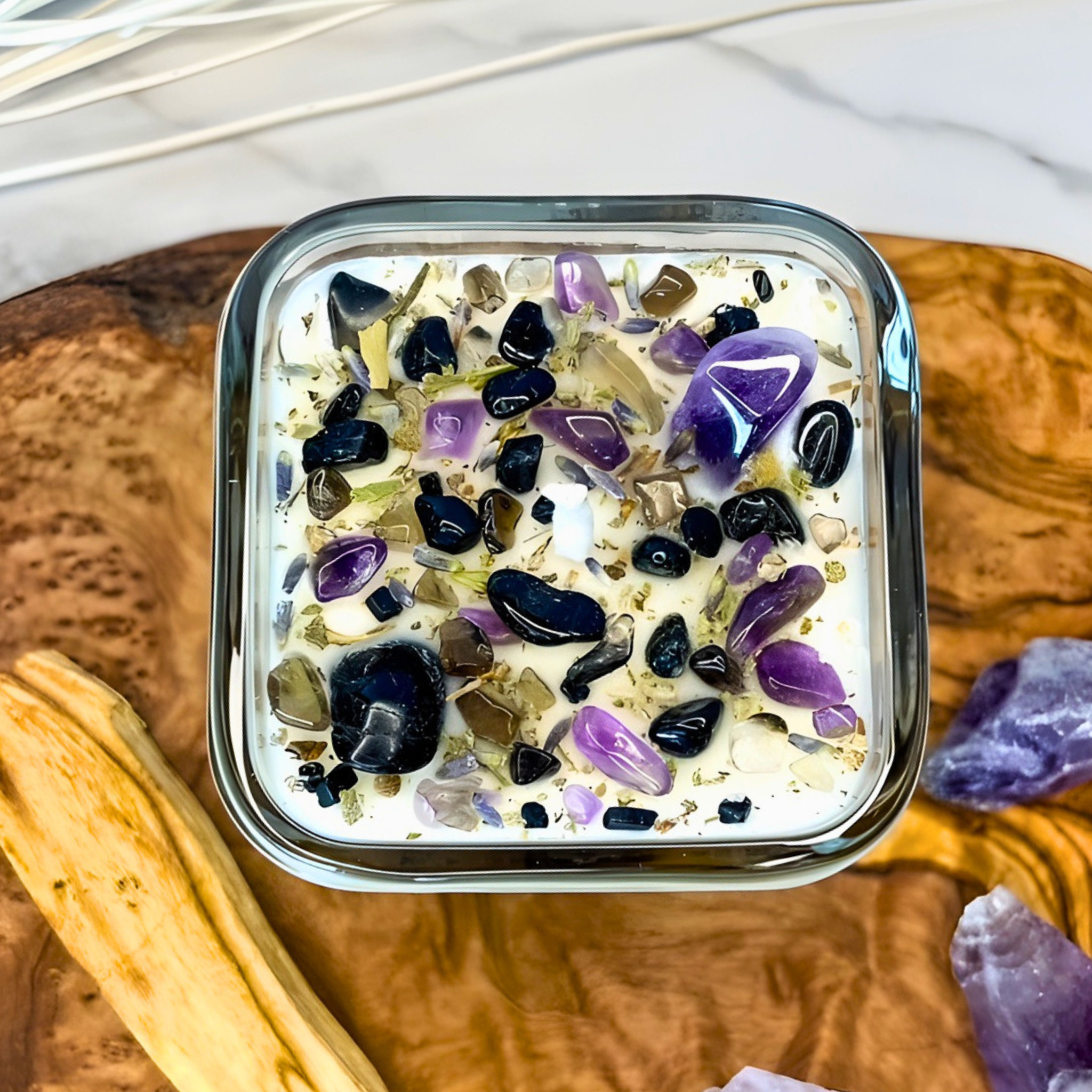 Square container with colorful stones on a wooden surface