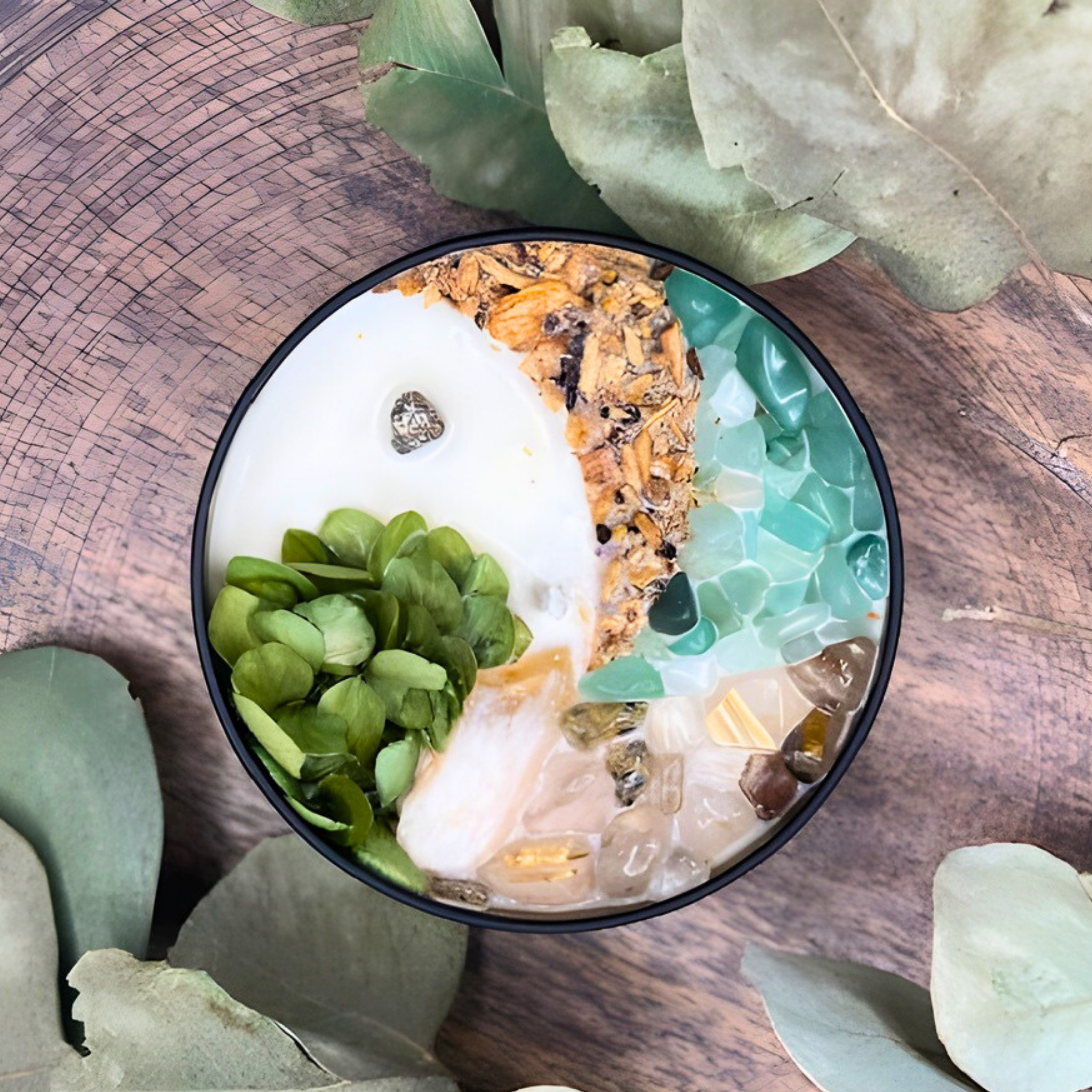 Decorative bowl with pebbles and plants on a wooden surface