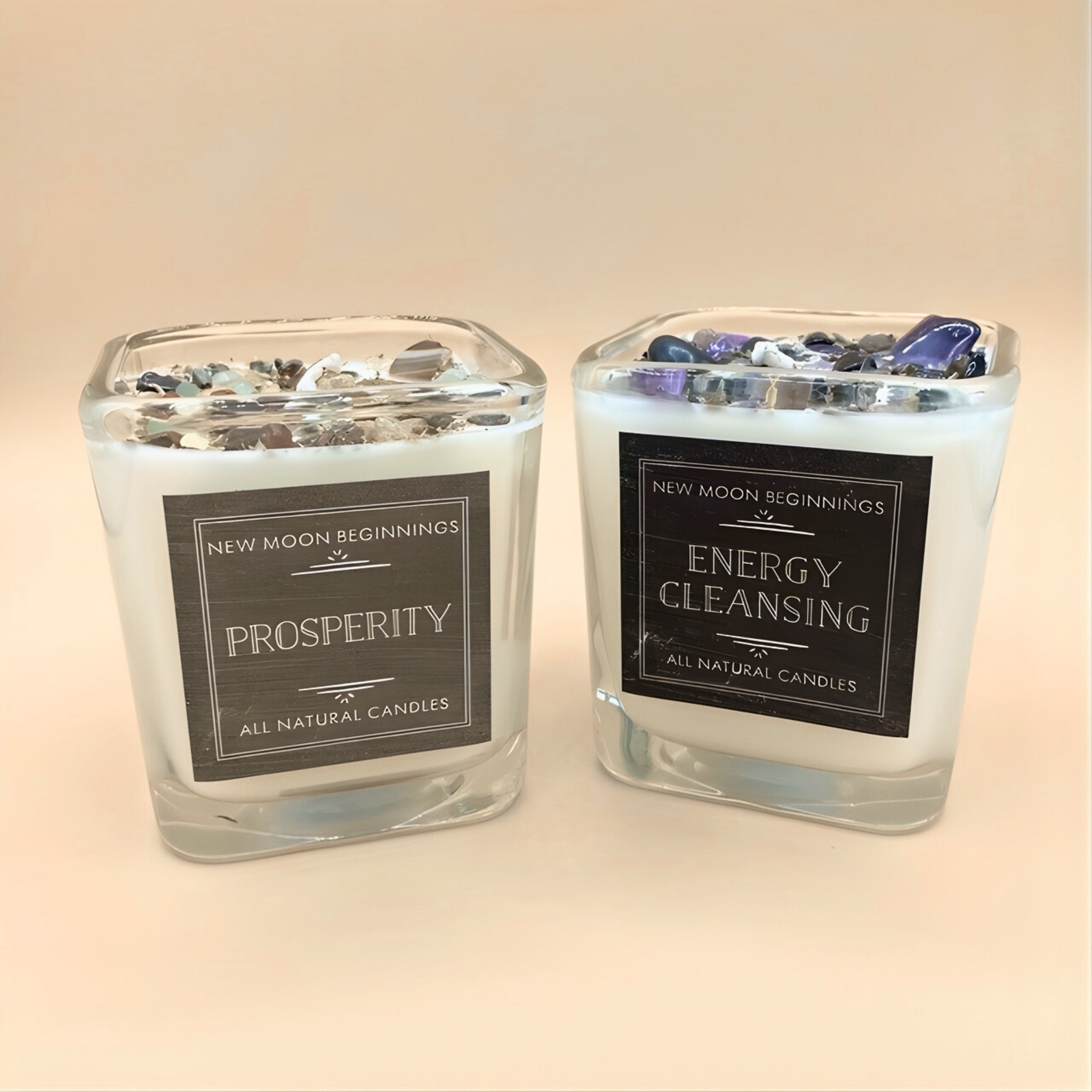 Two glass candles labeled 'Prosperity' and 'Energy Cleansing' on a light background