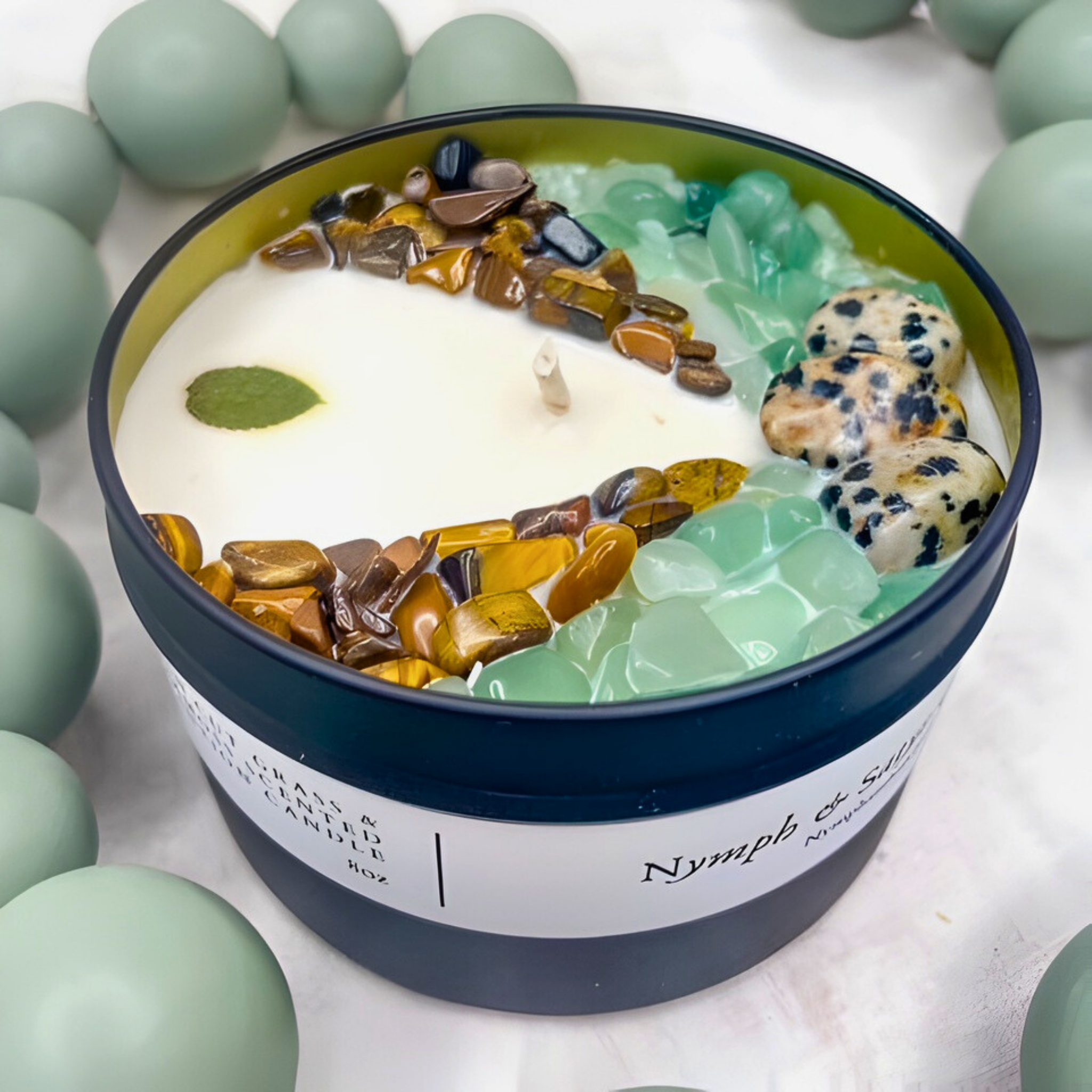 Candle with decorative stones and a label on a light background