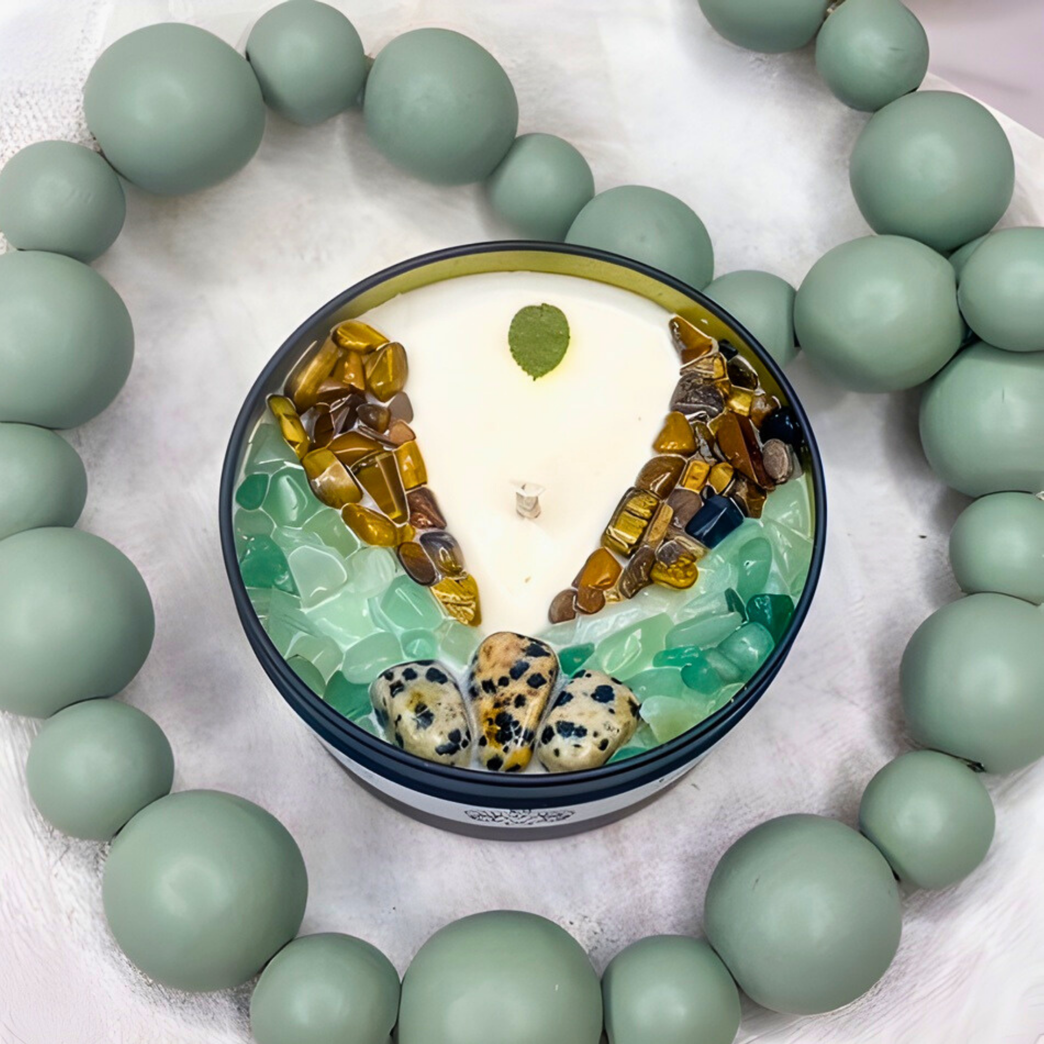 Candle with embedded stones and beads on a light background