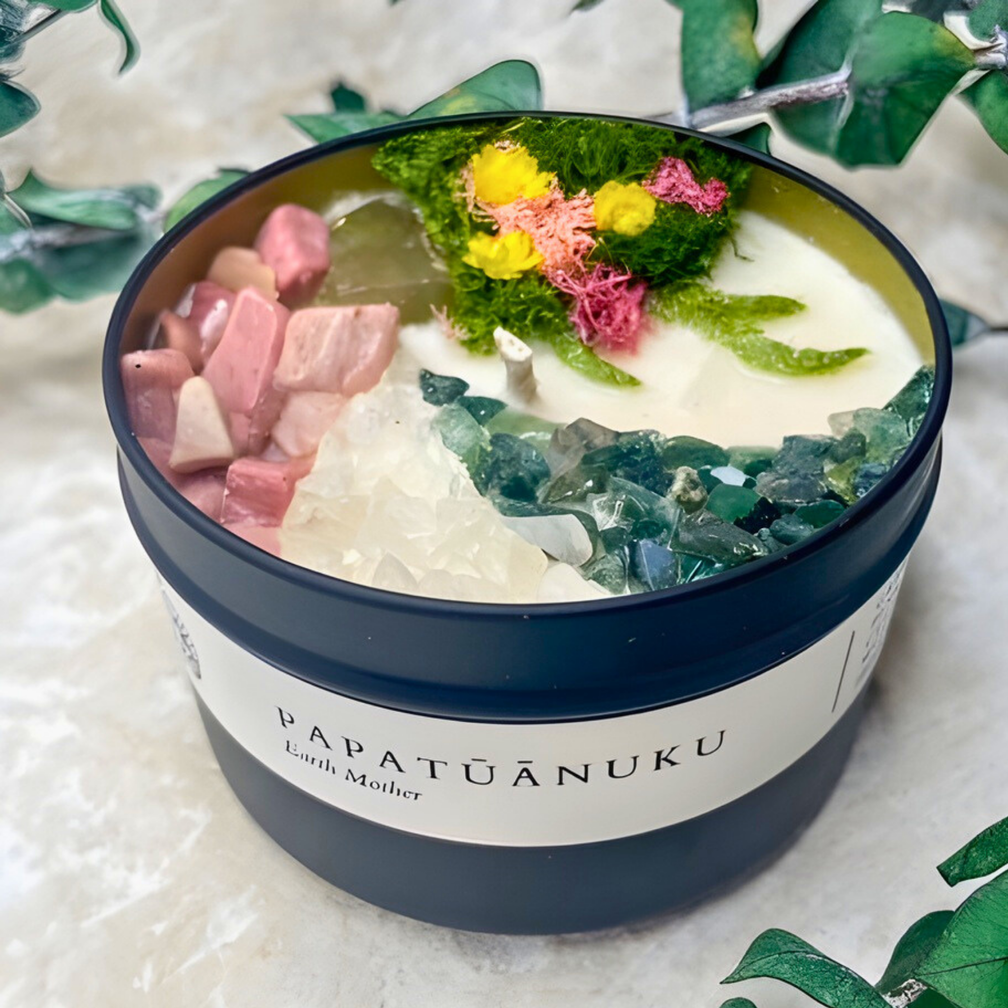 Candle in a container with decorative elements on a textured surface