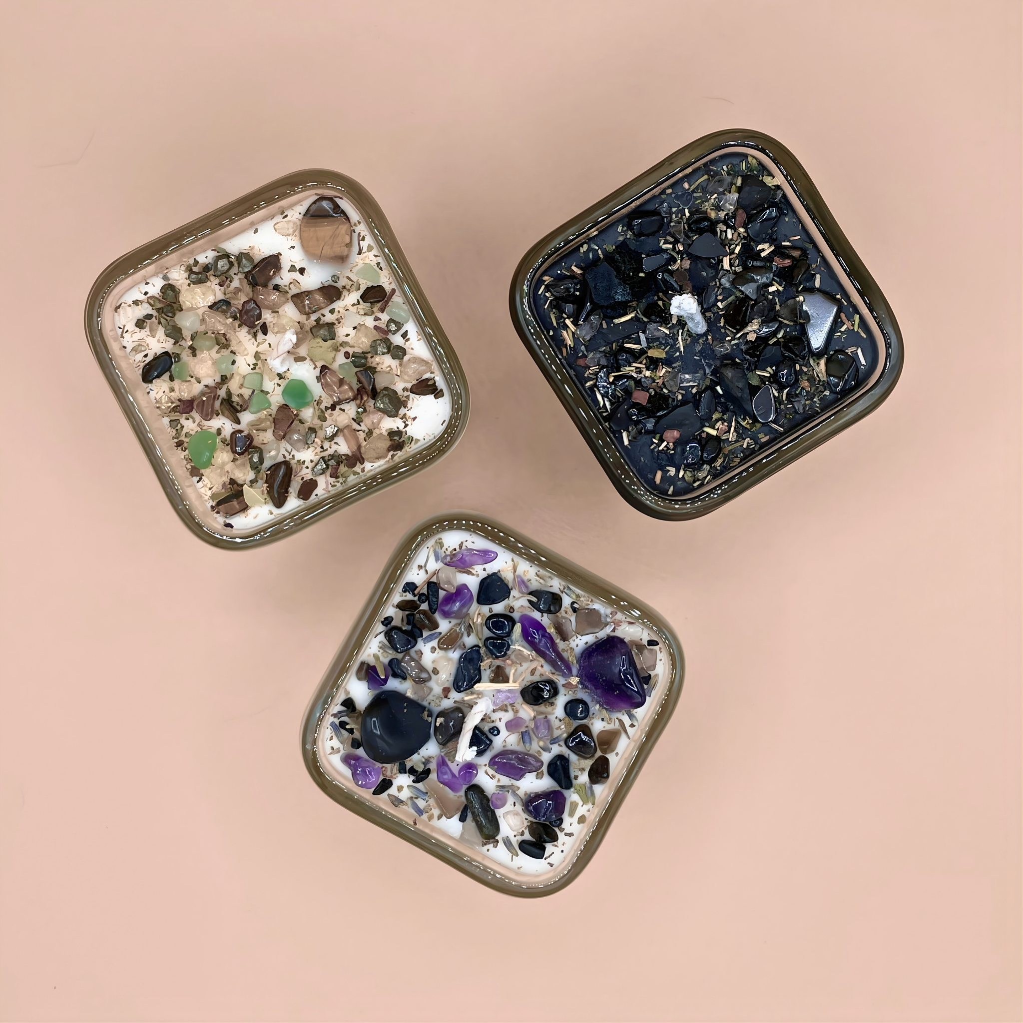 Three square decorative items with embedded stones on a beige background