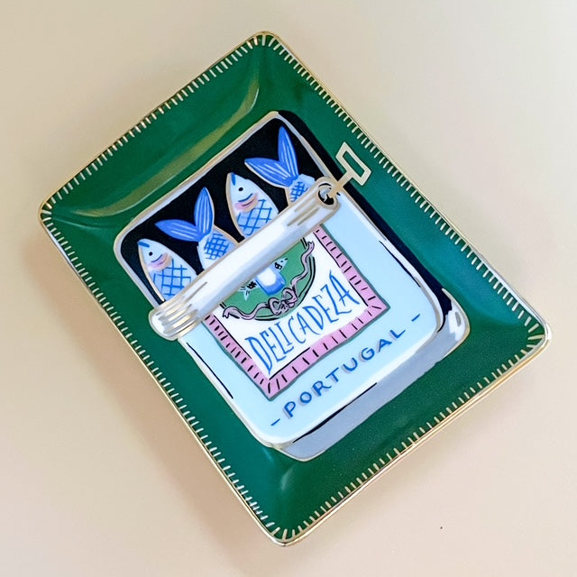 Decorative tin with a design of fish and text on a green tray